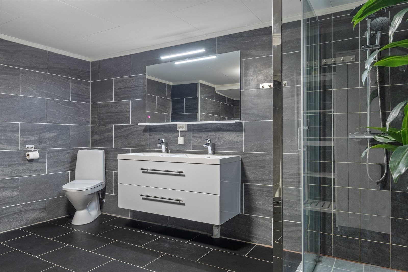 Badet har en romslig dusjnisje med glassdører. Galleribilde