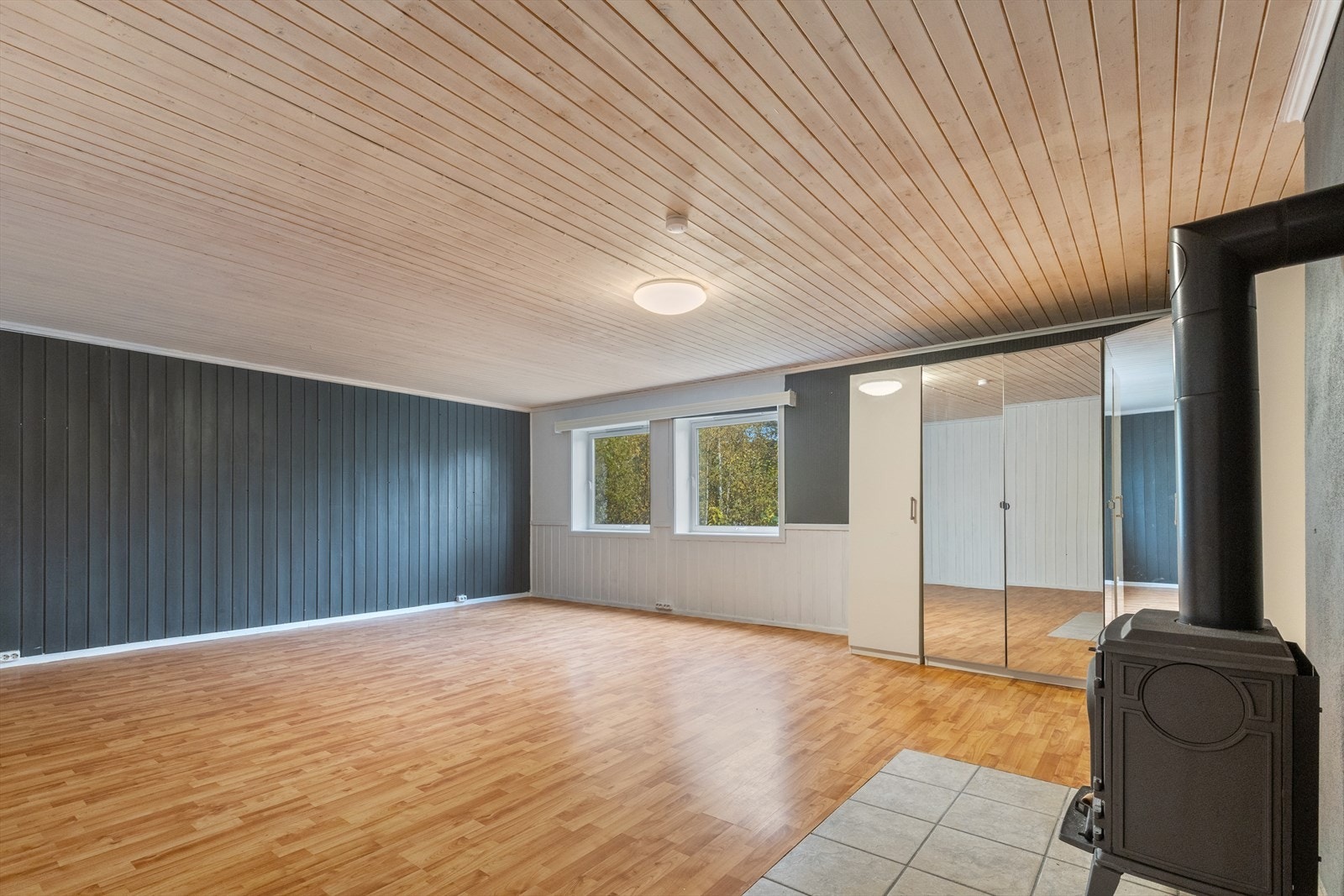 Kjellerstuen er utstyrt med et stort garderobe hjørneskap, peisovn, østvendte vindusflater med rullegardiner. Galleribilde