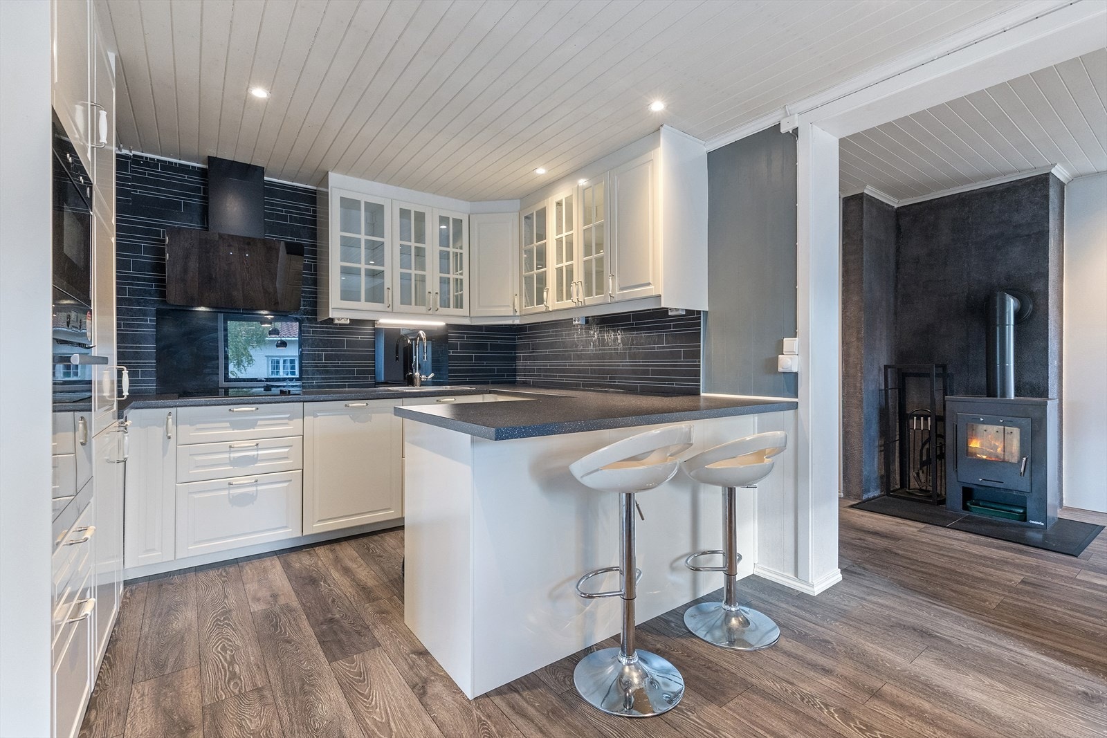 Kjøkken med integrerte hvitevarer og et moderne preg som ble pusset opp i 2021, har innredning med profilerte fronter og laminerte skrog, 6- overskap med glassfronter. Galleribilde