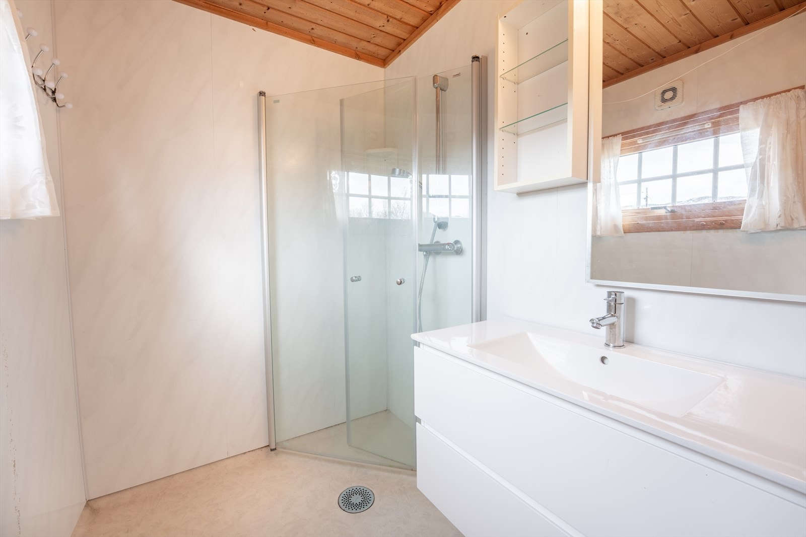 Bad har vinylbelegg på gulv, baderomsplater på vegger og trepanel i himling. Servantinnredning, håndvask, dusj med dører/vegger i glass. Galleribilde