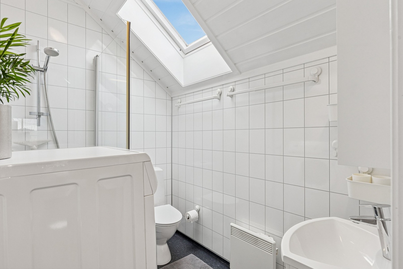 Rommet inneholder vask, dusj, toalett og opplegg for vaskemaskin. Galleribilde