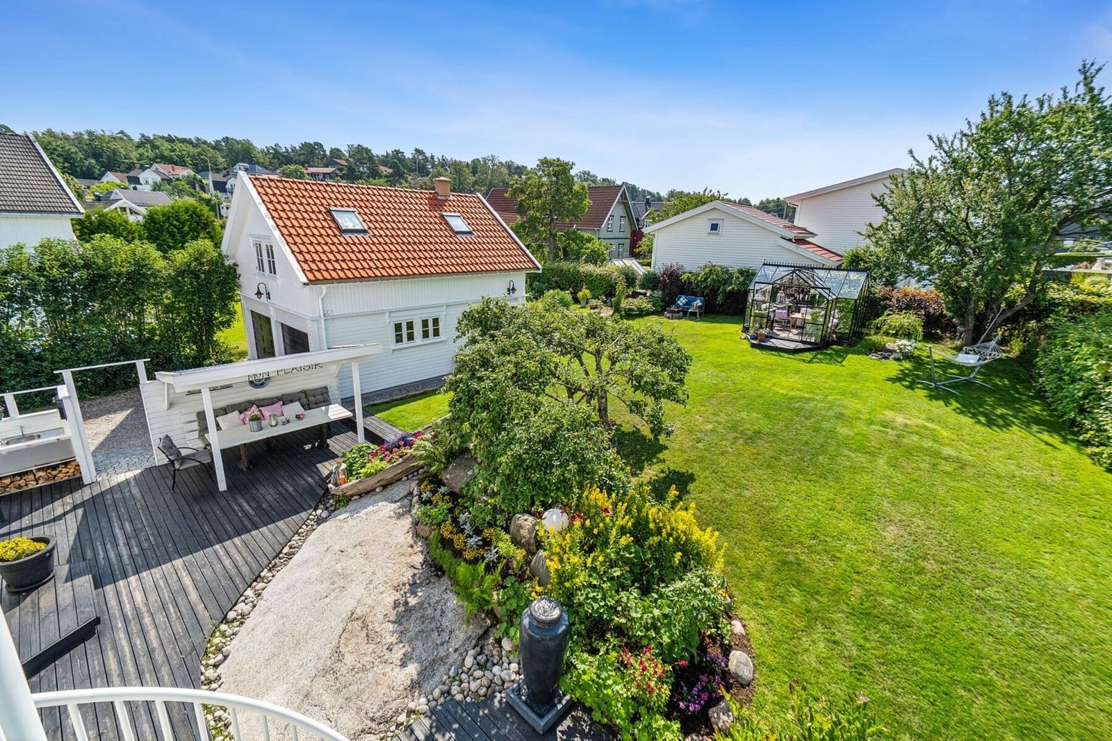 Her har man en stor solrik tomt på hele 1010 kvm med en dobbeltgarasje med leilighet i 2. etasje, og en idyllisk hage hvor både to og firbente kan kose seg hele dagen. Galleribilde