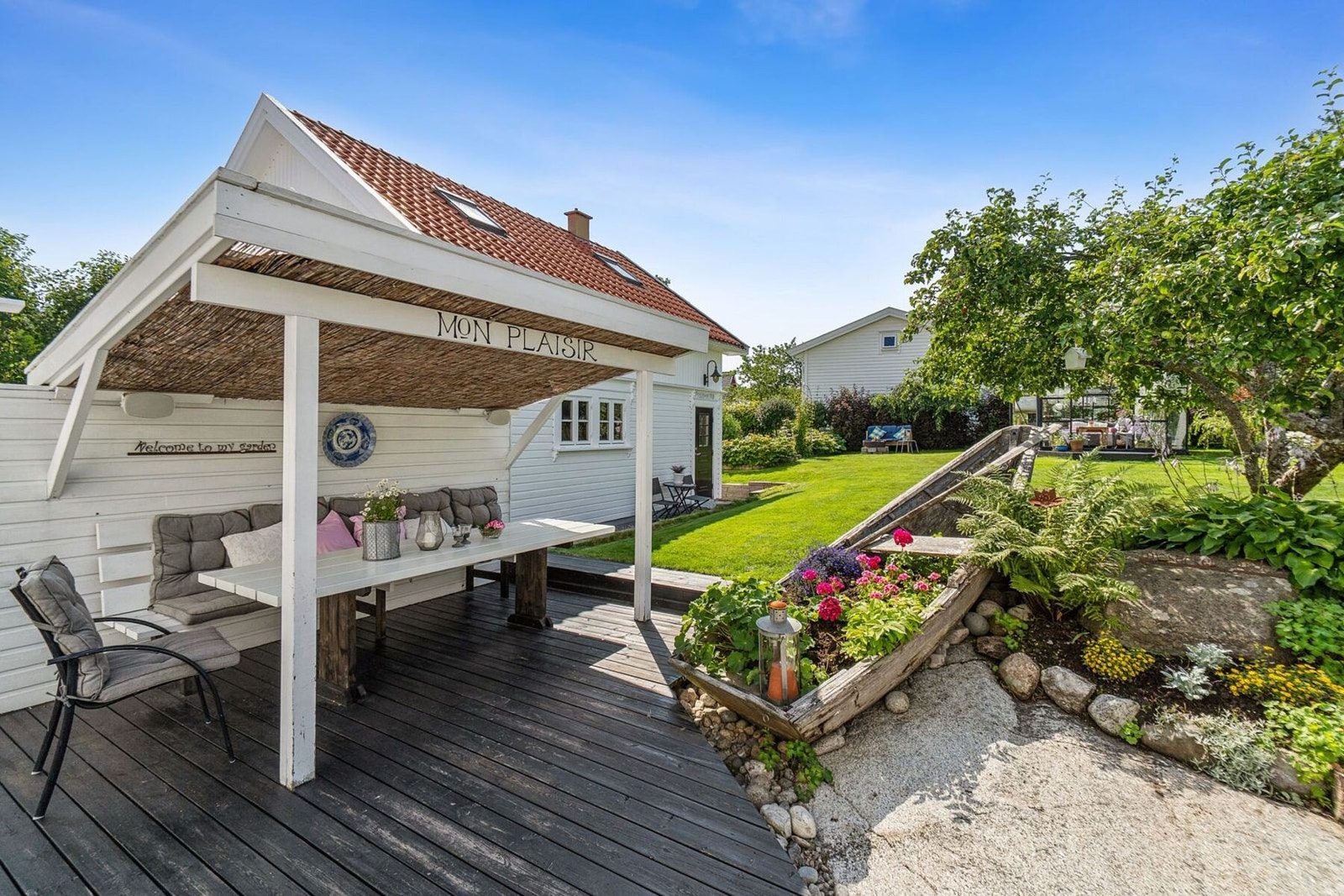 Den solrike eiendommen er vakkert opparbeidet med drivhus, kjøkkenhage, frodig beplantning og hyggelige sitteplasser. Galleribilde