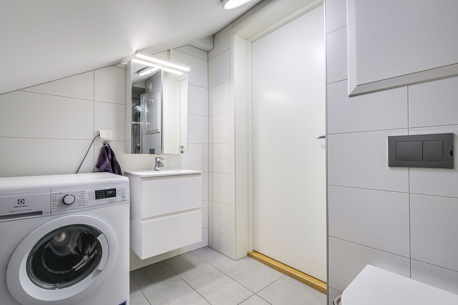 Lyst, flislagt bad med varmekabler i gulv og opplegg til vaskemaskin fra 2022 Galleribilde