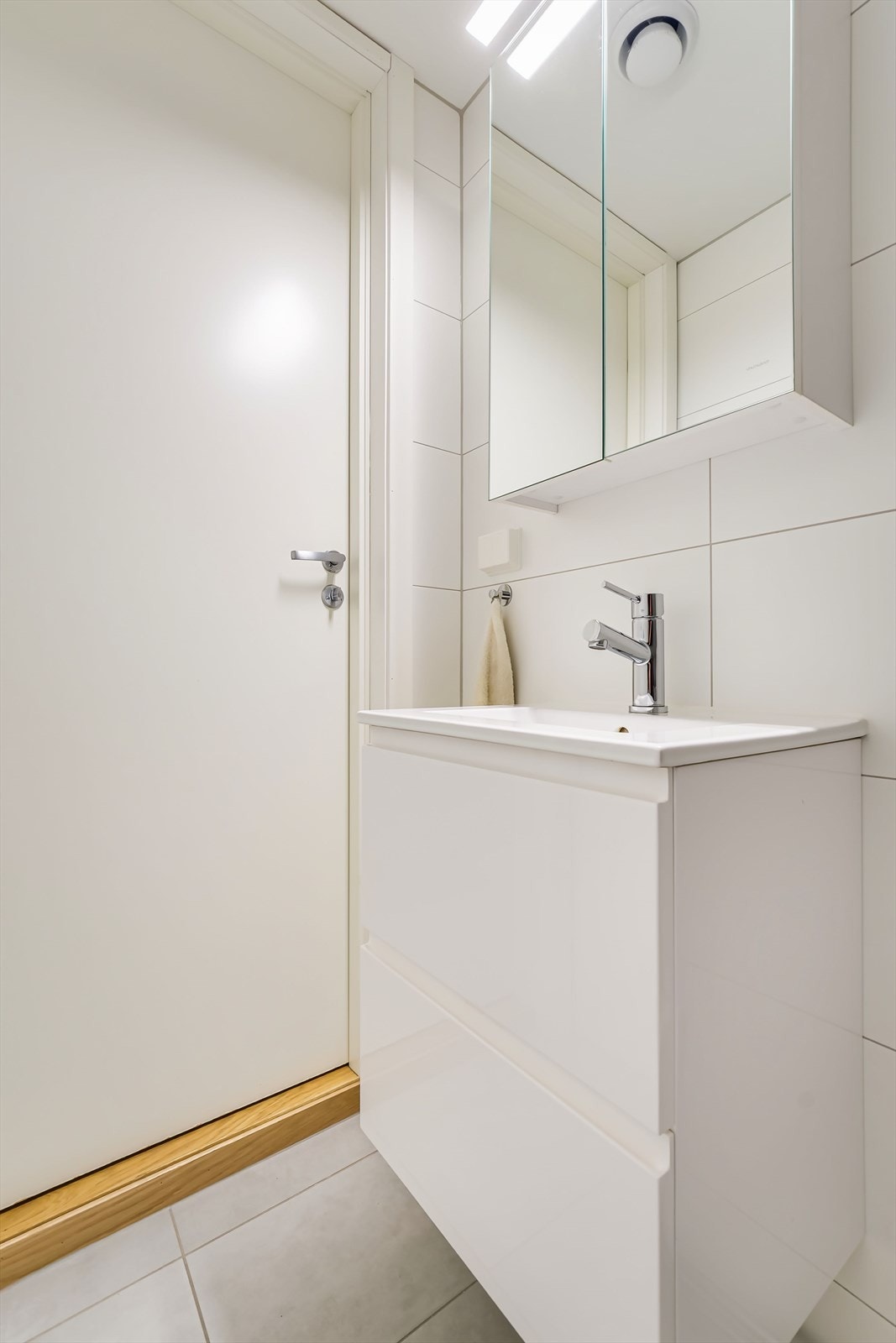 Servantskap med glatte, folierte fronter og speilskap med lysarmatur Galleribilde