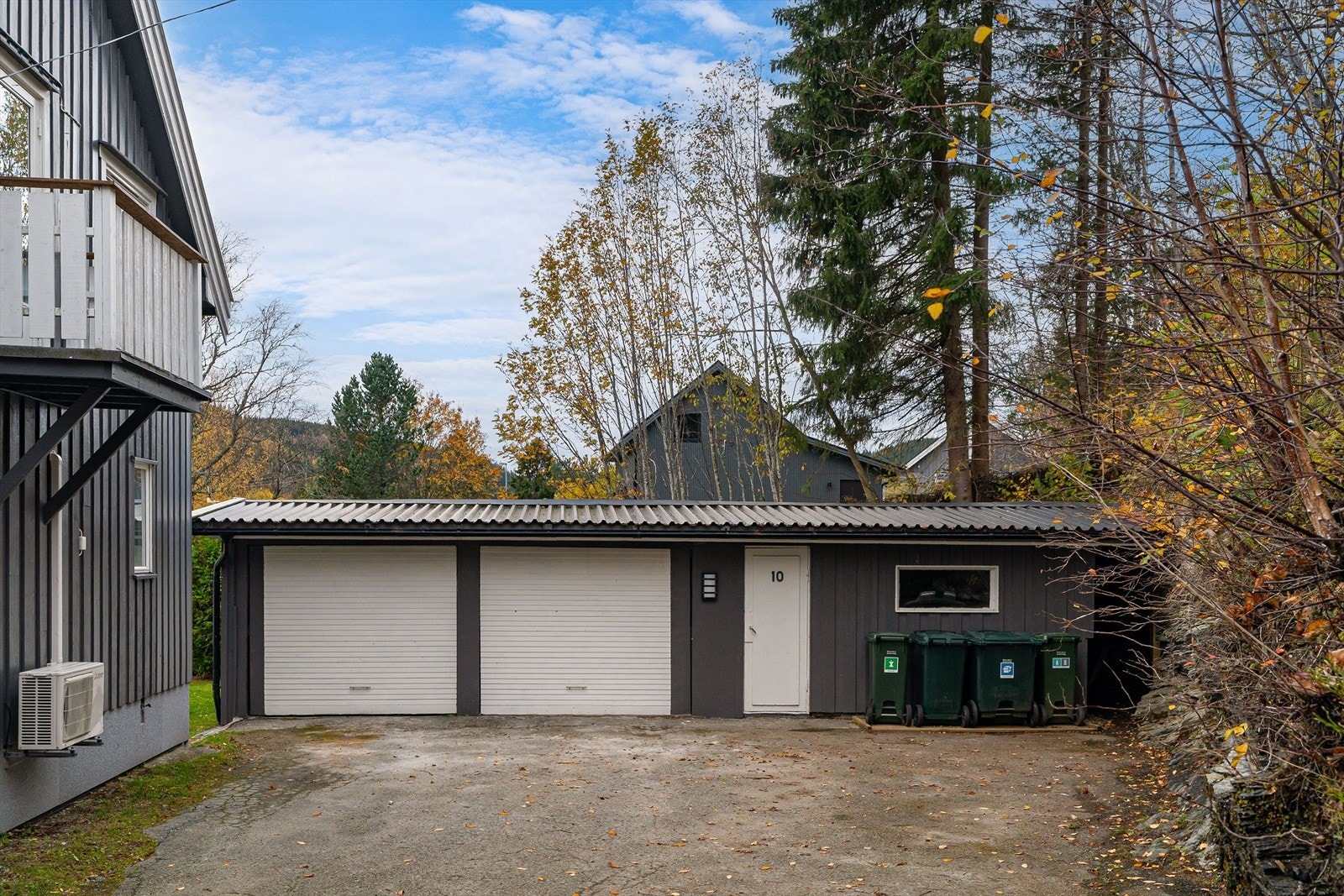 Eiendommen har asfaltert gårdsplass og en dobbelgarasje med elbillader for parkering. Galleribilde