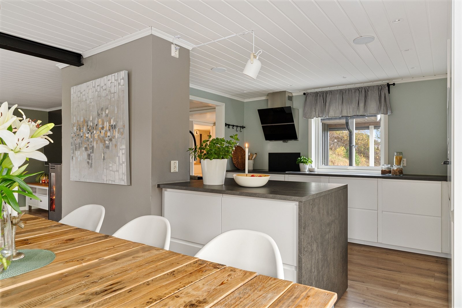 Kjøkkenet har hvite, håndtaksløse fronter som harmonerer fint til stuens overflater. Galleribilde