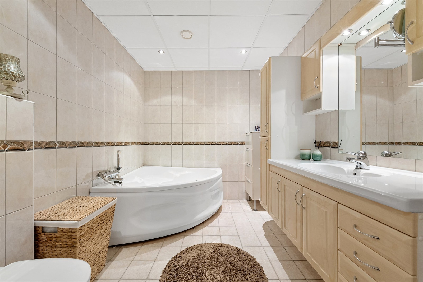 Leiligheten har to flislagte baderom. Baderom 1 er utstyrt med servant, toalett og badekar. Galleribilde