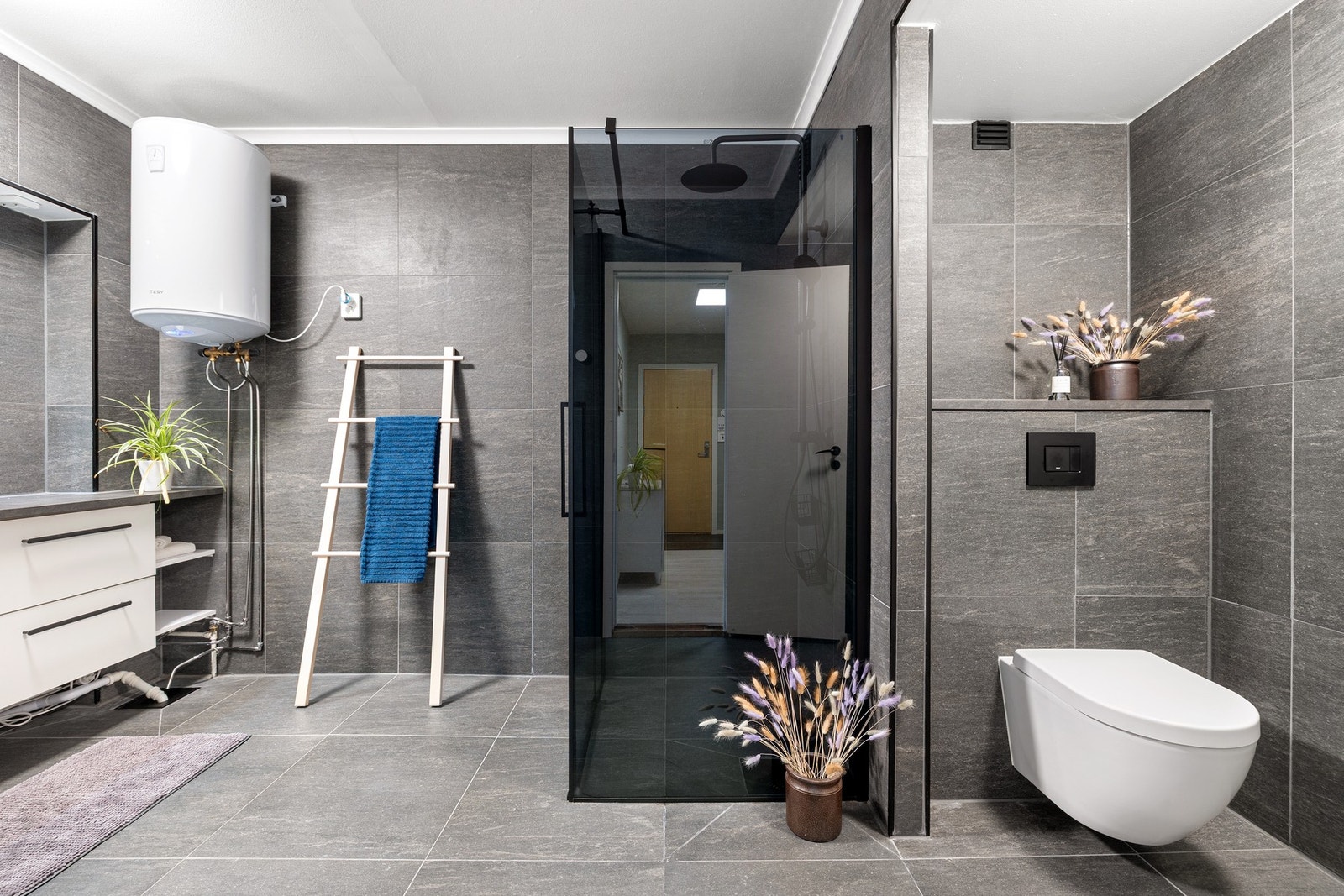 Romslig bad med flislagte overflater og lun gulvvarme. Moderne innredning med toppmontert servantskål. Galleribilde