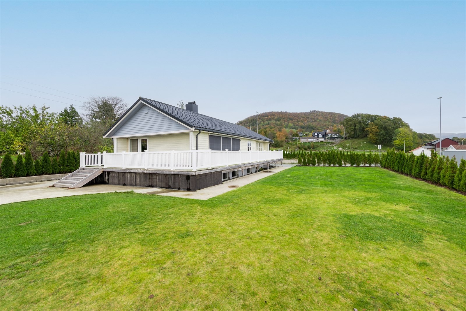 Romslig gressplen omkranset av hekk som gir både privatliv og en grønn ramme rundt eiendommen. Galleribilde