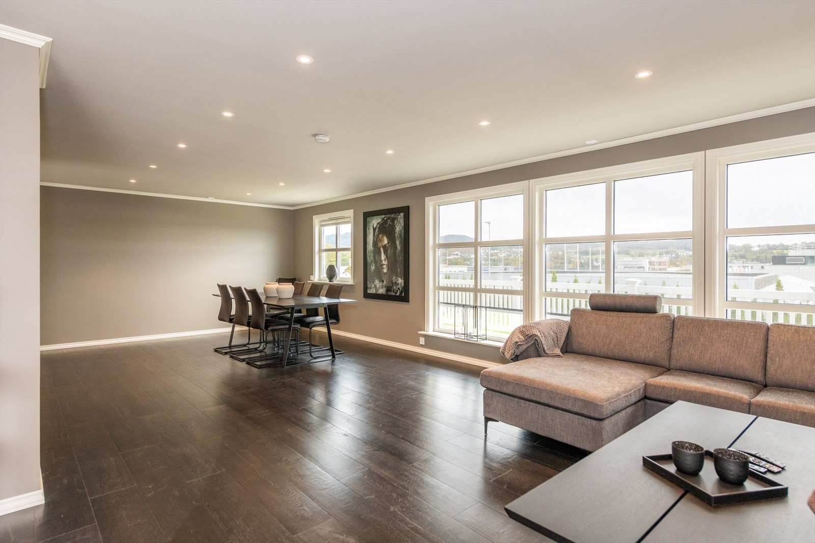 Lys og innholdsrik stue med store vindusflater ut mot hagen. Galleribilde