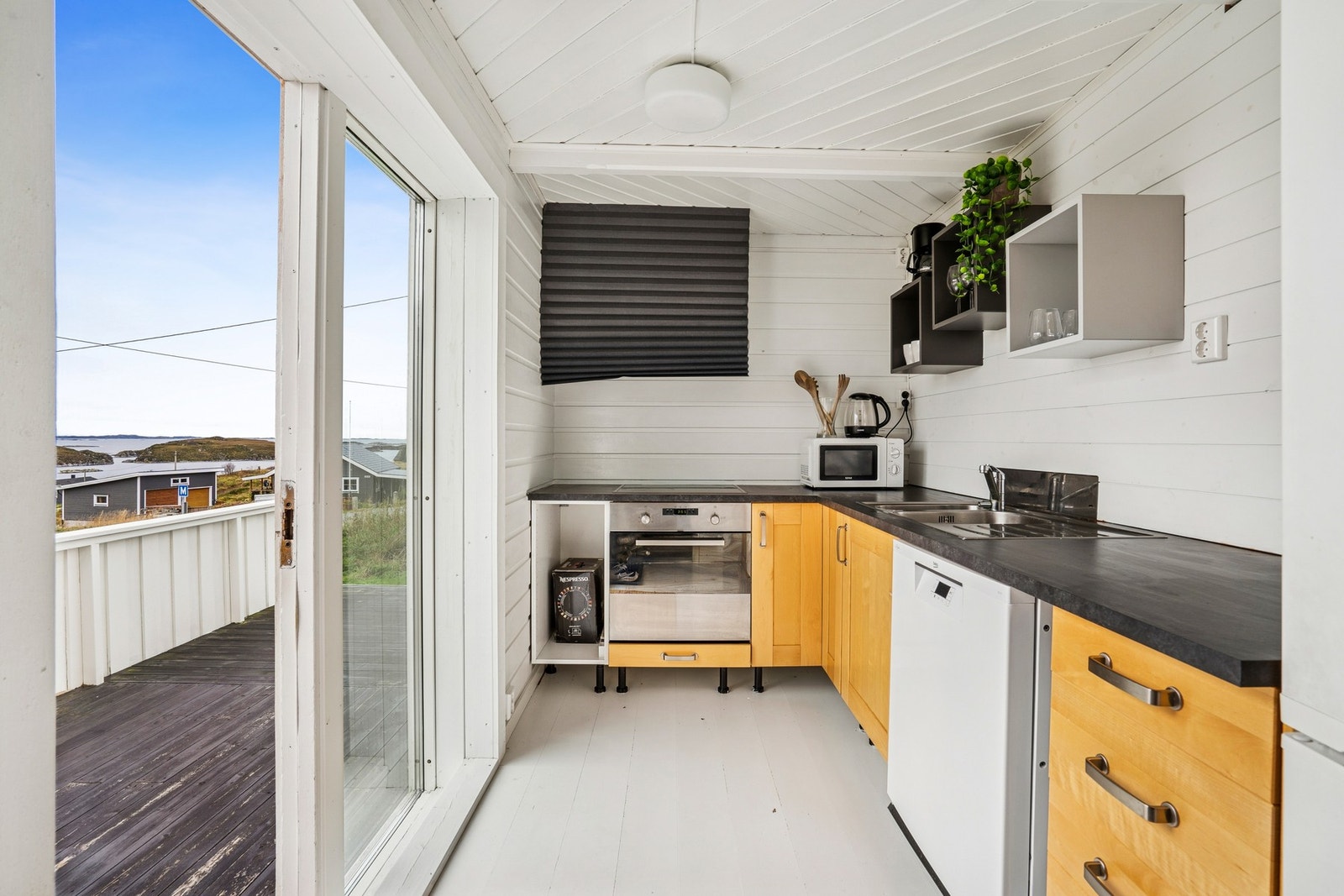 Kjøkkenet har praktisk utforming og god plass til nødvendige hvitevarer. Galleribilde