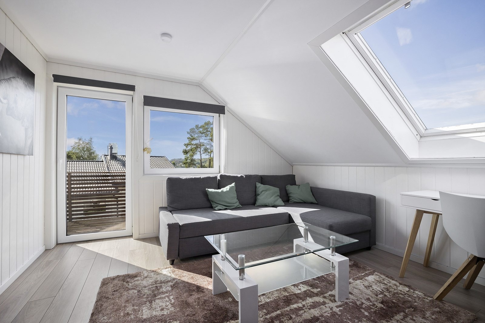 Stuen har store vindusflater og utgang til stor balkong hvor man kan skimte sjøen. Galleribilde