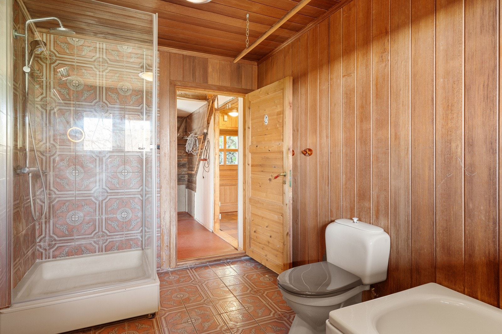 Badet er utstyrt med dusjkabinett, servant, badekar og toalett. Galleribilde