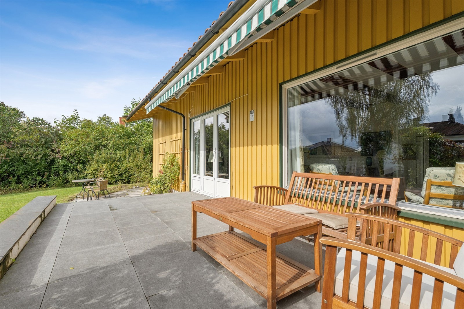 Det er sømløs overgang mellom stue, terrasse og hagen. Galleribilde