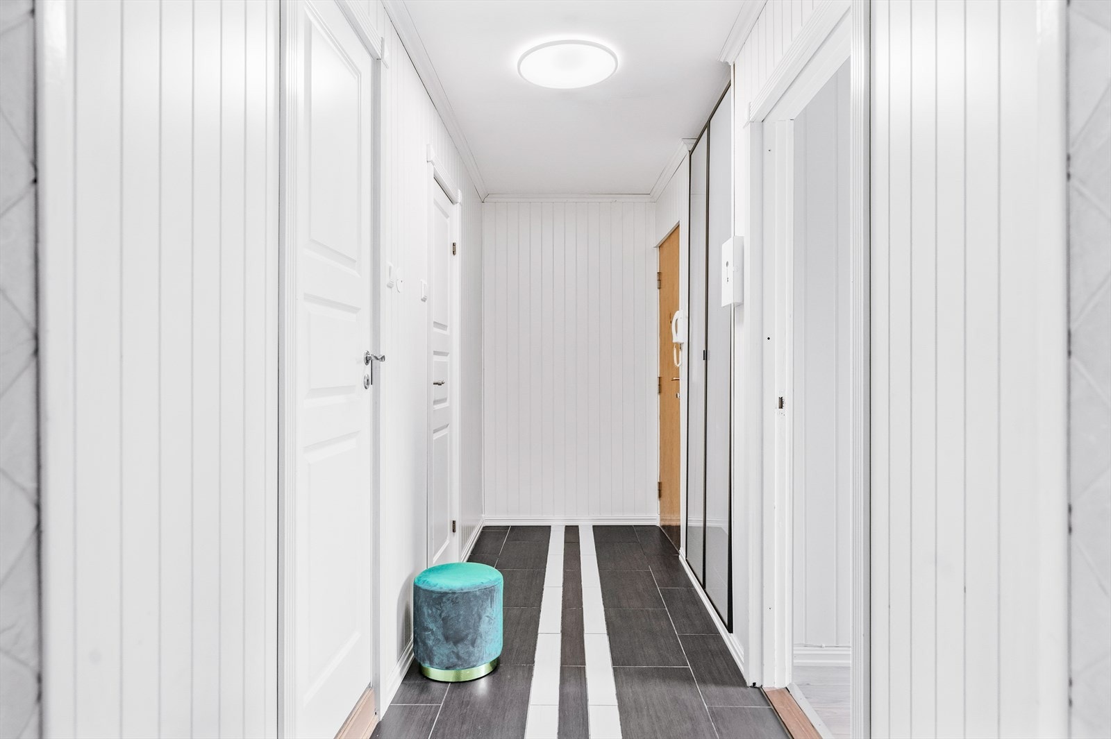 Leiligheten har en lys entré med plass til å henge fra seg yttertøy i nisje med skyvedører. Dørcalling med åpner gjør det enkelt å slippe inn gjester fra bakkeplan. I tillegg disponerer boligen to kjellerboder med ekstra lagringsplass. Galleribilde