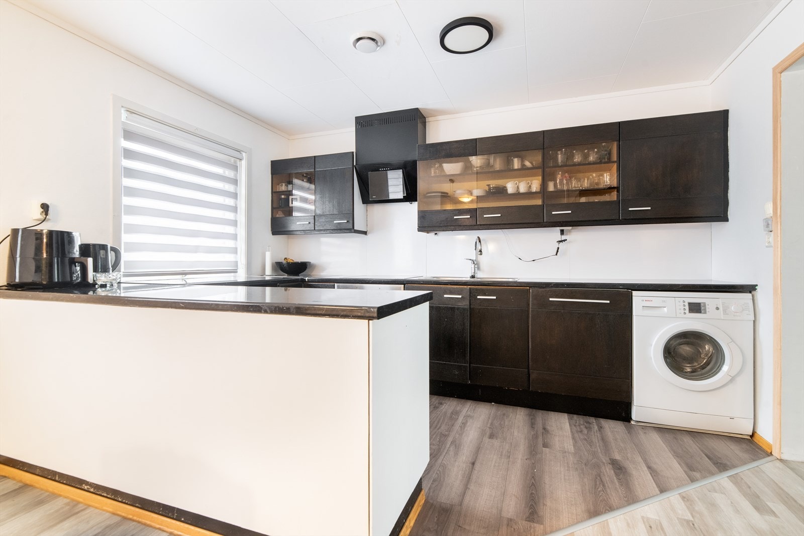 Kjøkkeninnredningen har slette fronter og noe glasskap, samt laminat benkeplate. Det er kjøkkenventilator fra 2015 og integrert oppvaskmaskin, komfyr og platetopp. Galleribilde