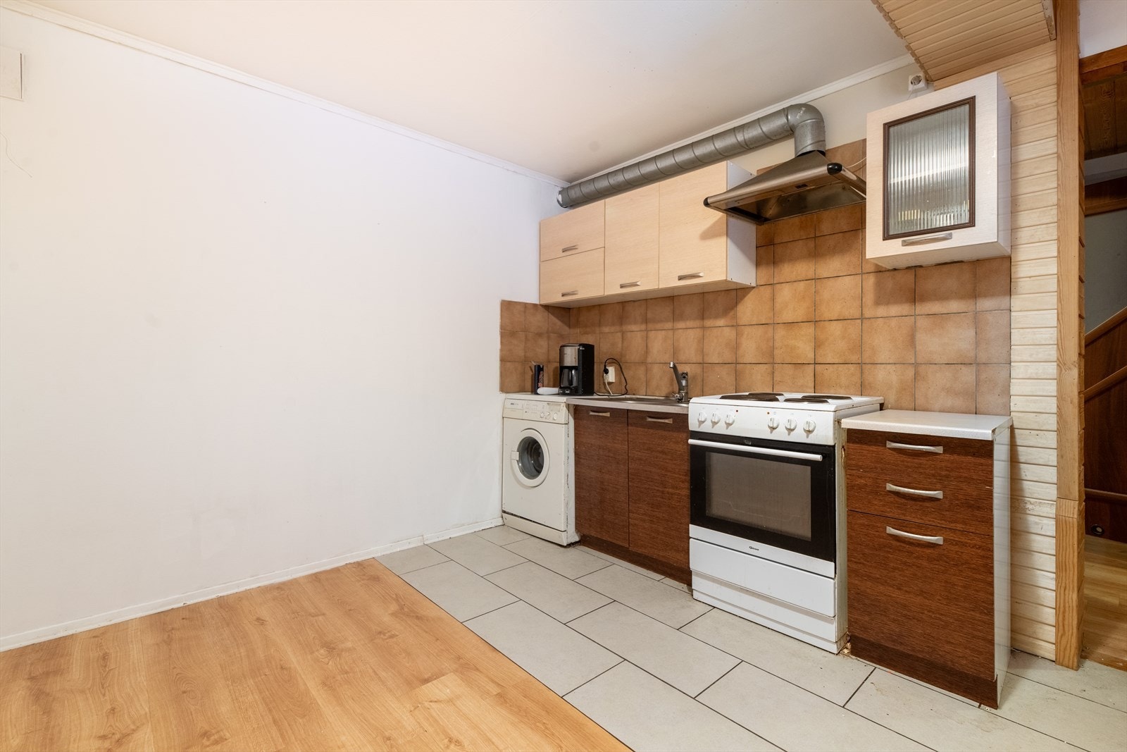 Kjøkkenet har innredning med slette fronter, laminat benkeplate og flis over kjøkkenbenk. Det er ventilator og avsatt plass til komfyr og kjøleskap, samt opplegg for vaskemaskin. Galleribilde