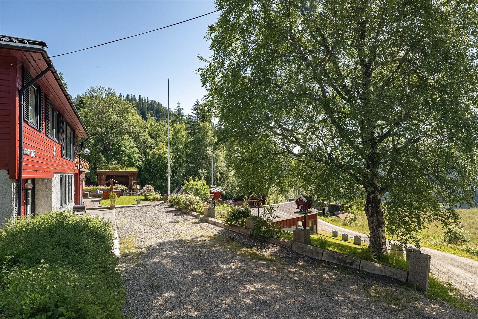 Inngangsparti og innkjørsel på nedsiden og hovedinngangen til huset Galleribilde