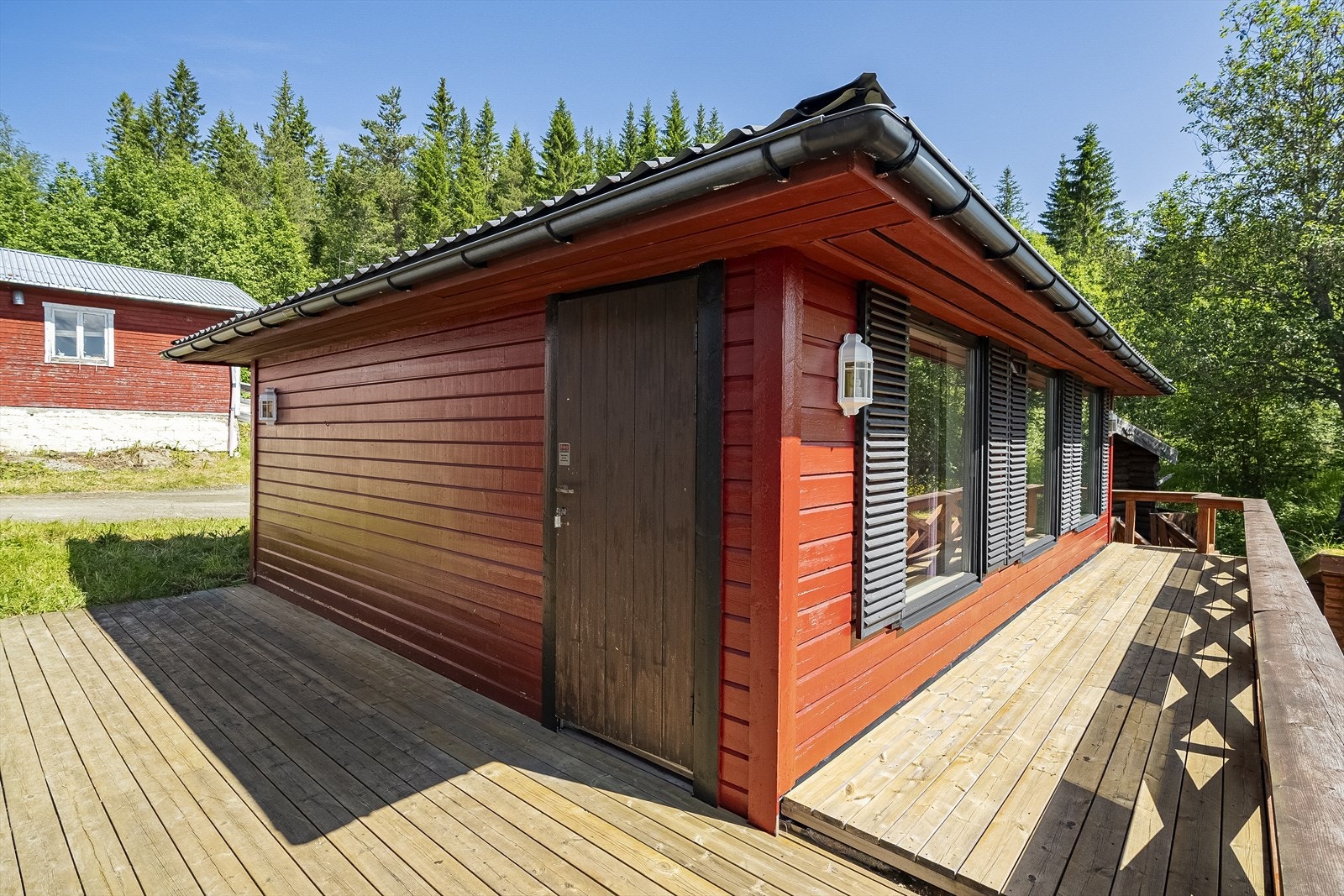 Terrasse som forbinder hovedhus og ekstrabygget som tidligere har vært svømmebasseng og i dag et større oppholdsrom med bar Galleribilde