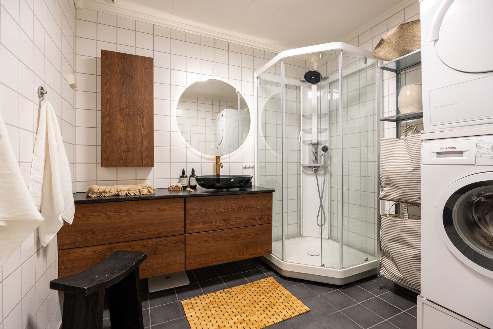 Romslig helfliset bad med opplegg og plass for både vaskemaskin og tørketrommel. Galleribilde