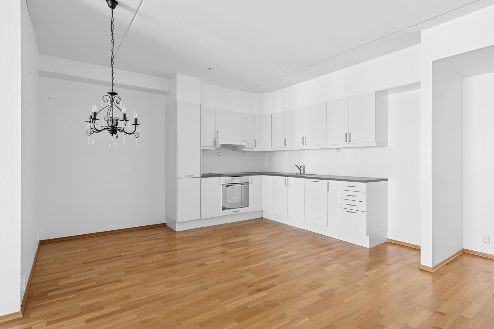 Stilrent og funksjonelt kjøkken med hvite, glatte fronter og godt med skap- og benkeplass. Galleribilde