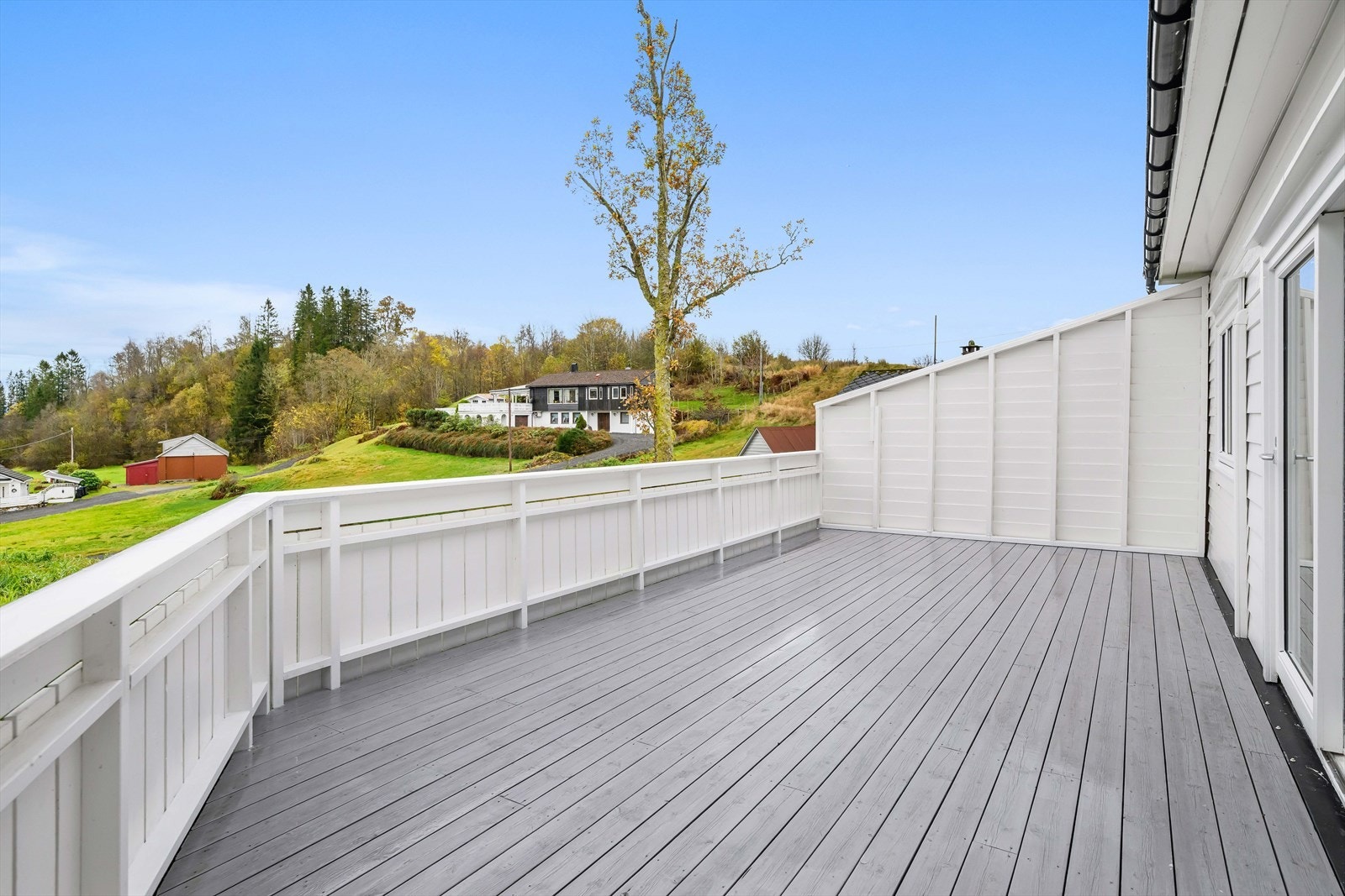 Stor solrik terrasse med utsikt mot nærområdet. Galleribilde