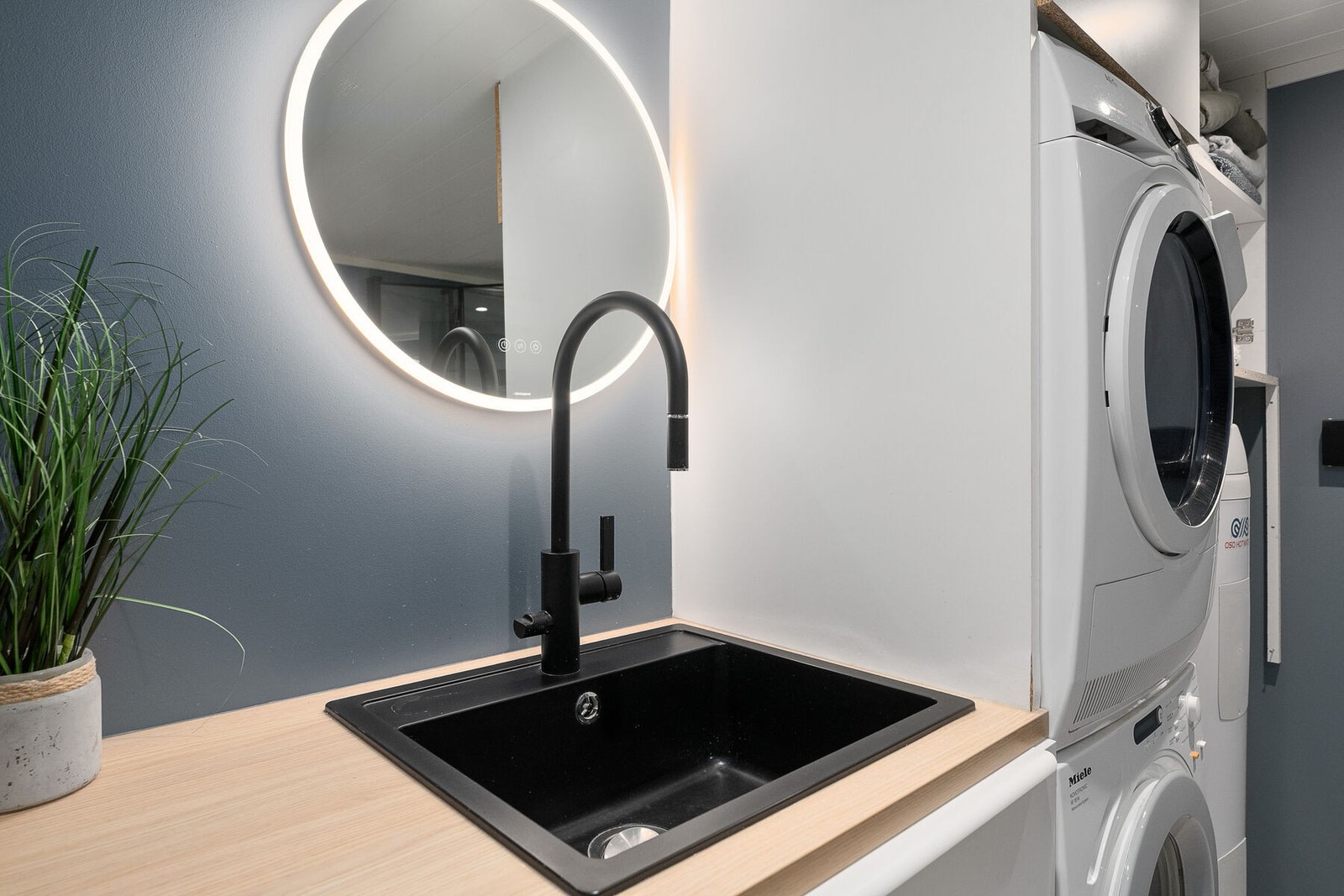 Rommet er utstyrt med baderomsinnredning med nedfelt skyllekar, veggmontert toalett, dusjvegger og opplegg for vaskemaskin. Galleribilde