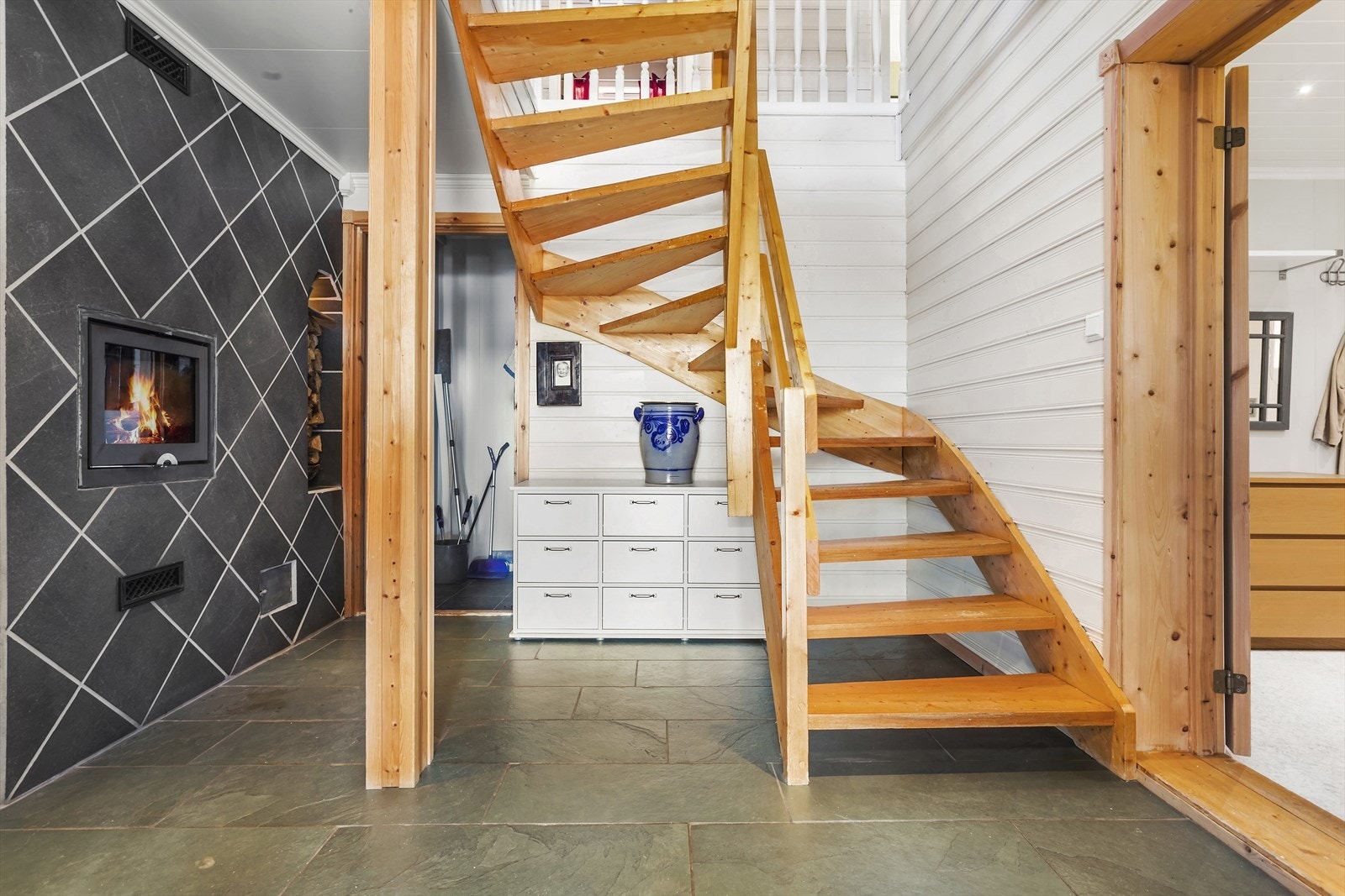 Fra ytterdøra som ble montert i 2021, kommer man i en fomslig hall. Peisoven og gulvvarme sørger for god behagelig varme. Det er forøvrig gulvvarme i hele u-etasjen utenom bodene. Galleribilde