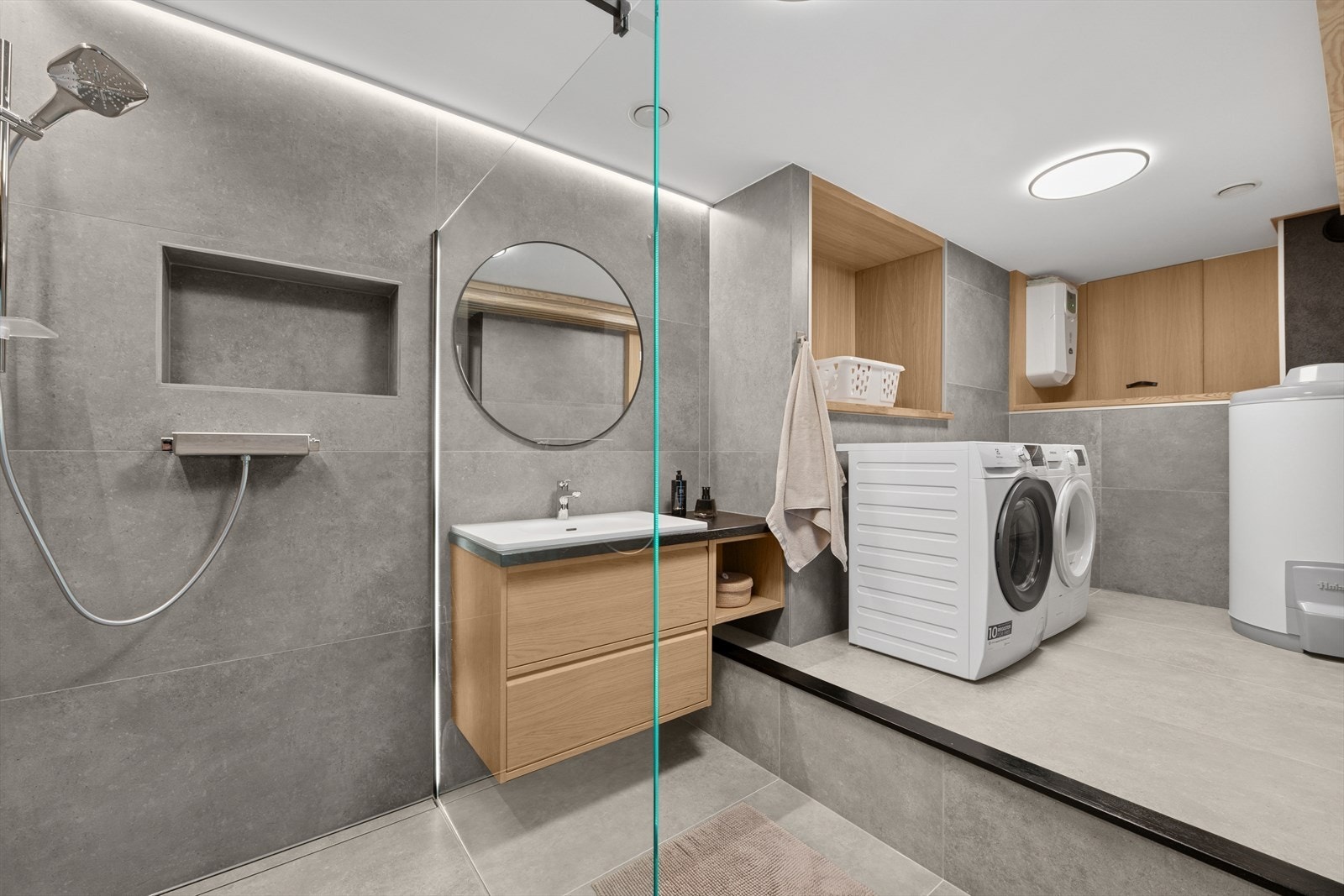 Baderommet i underetasjen er kombinert med vaskerom og går over to nivå. Nivåforskjellen skaper et naturlig skille mellom baderommet og vaskerommet. Galleribilde