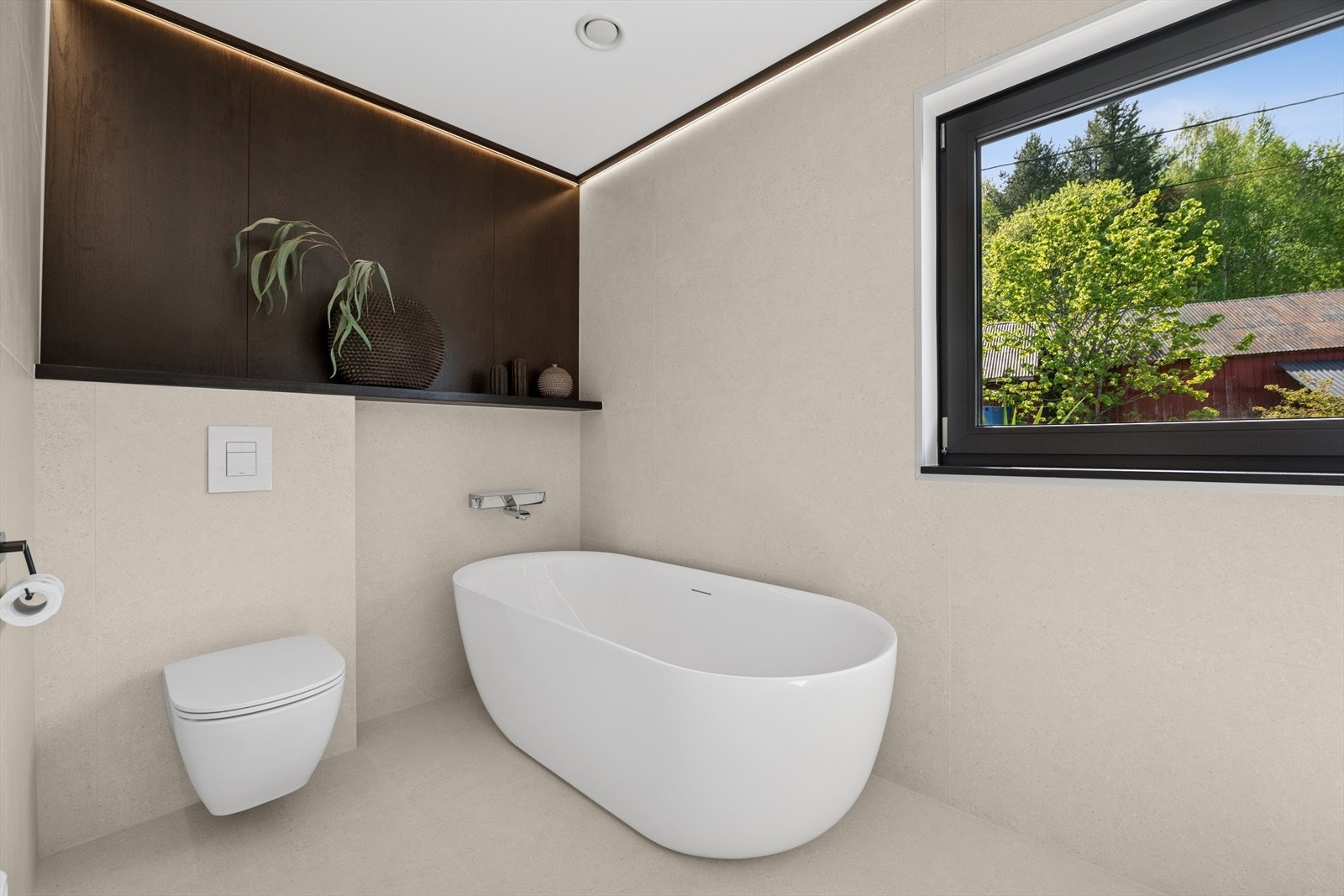 Baderommet i hovedetasjen er delikat og tidløst innredet med store, lyse fliser på gulv og vegger. I gulvet har man også varmekabler for ekstra komfort. Galleribilde