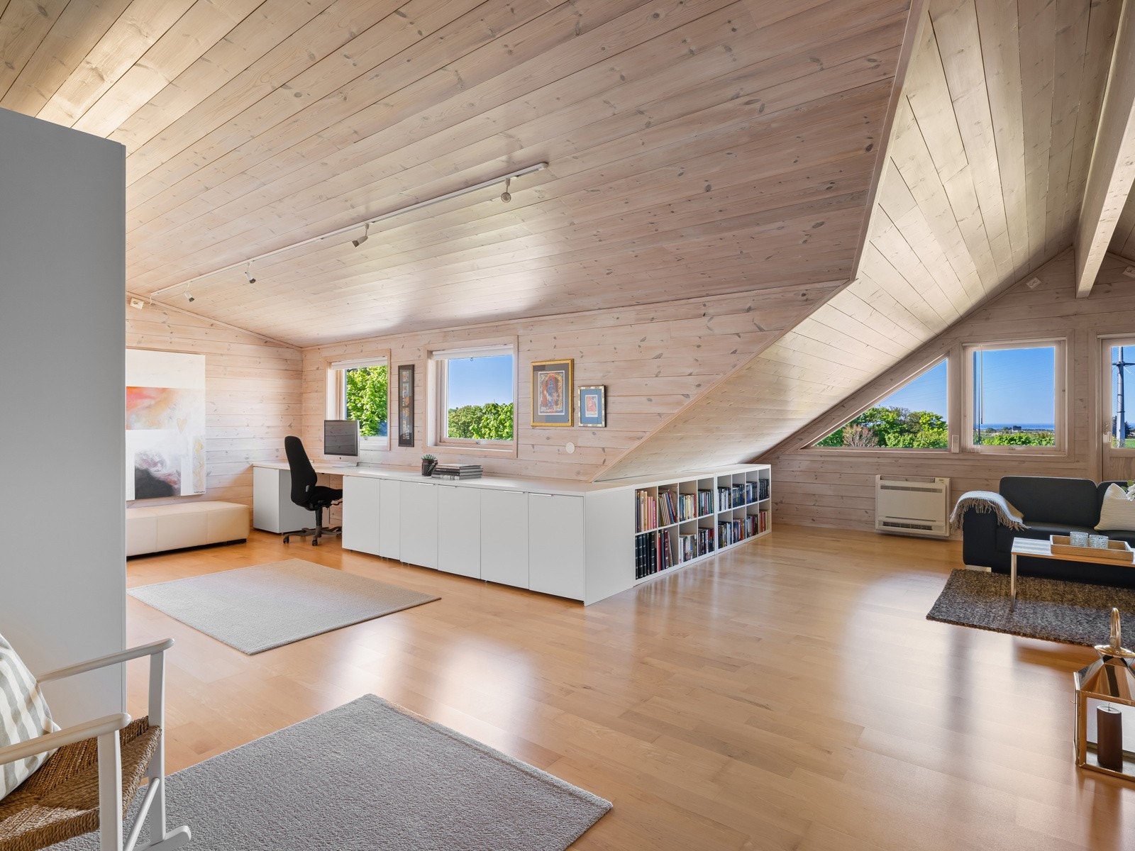 Loftstuen er romslig og innbydende, med panel på veggene og 3-stavs parkett på gulvet. Galleribilde