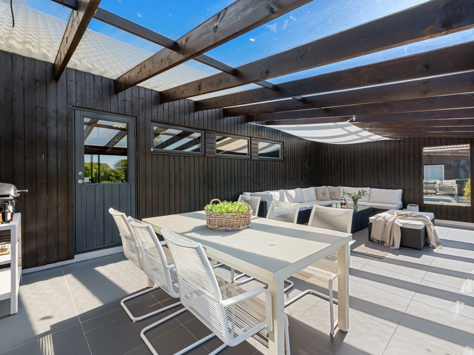 Med store skyvedører i glass åpnes rommet naturlig mot hagen og gir deg fullt utsyn til det vakre landskapet og havet i det fjerne. Galleribilde