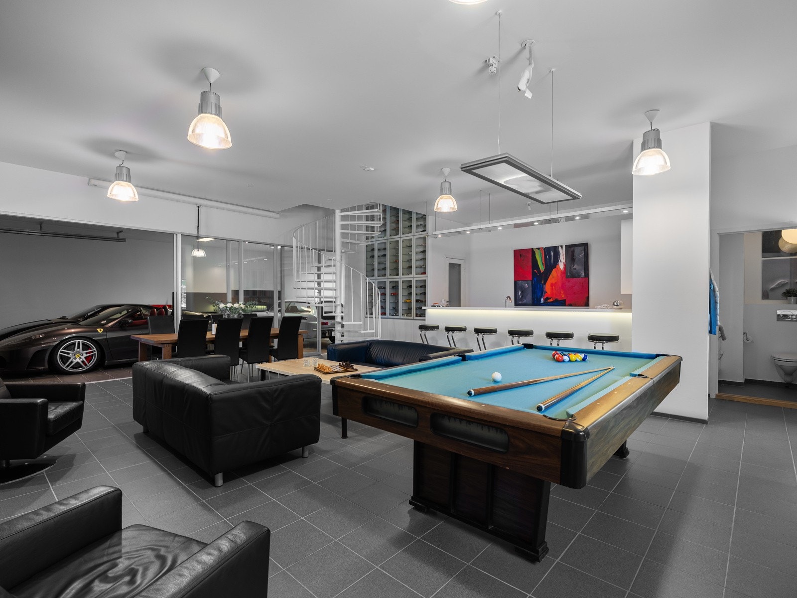 Store glass-skyvedører åpner opp mot garasjen, og gir en industriell og åpen følelse - perfekt for sosiale samlinger med garasjeporten åpen og stemningen på topp. Galleribilde