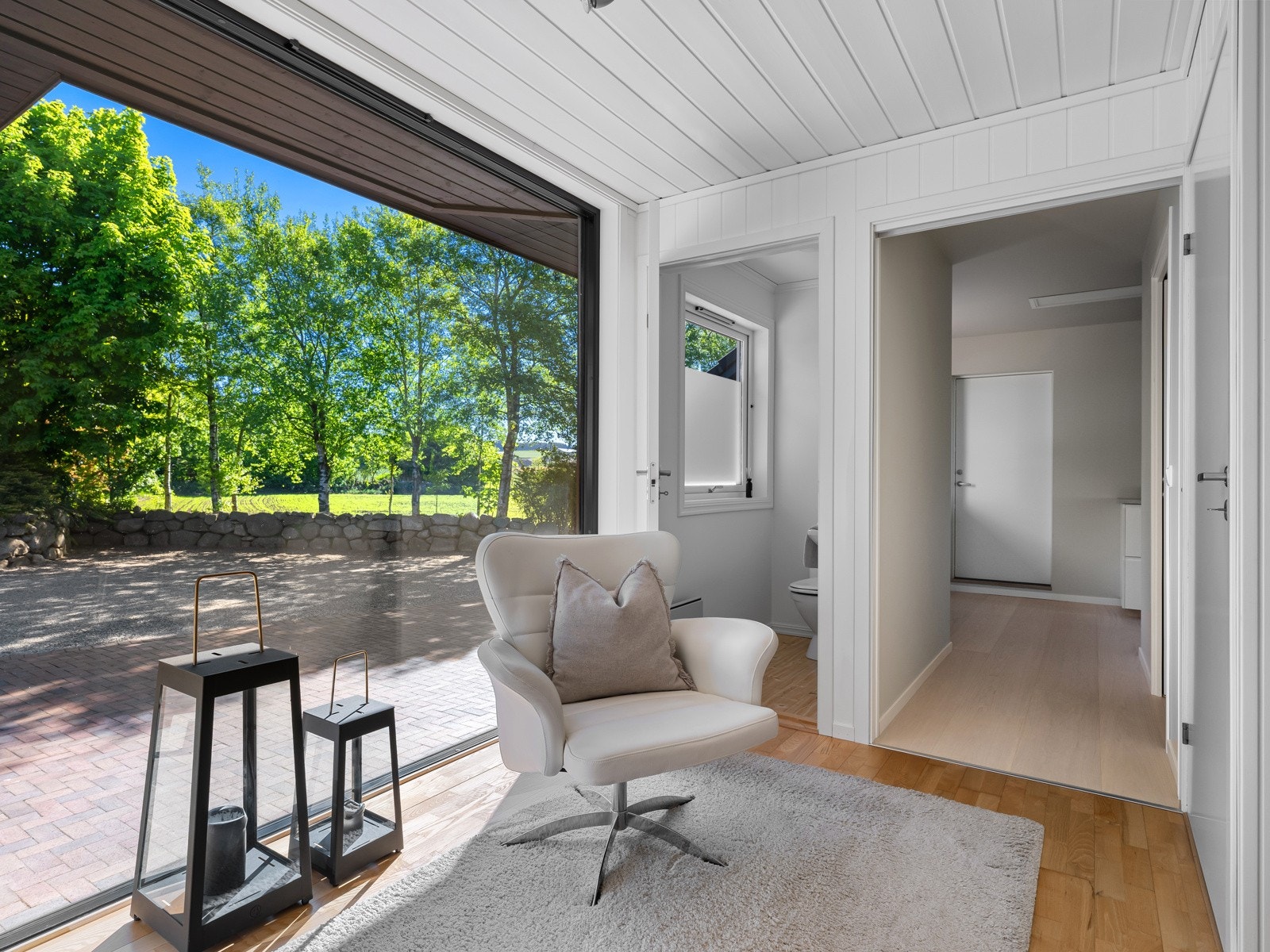 Videre inn i boligen møtes du av en lys og luftig gang med et flott vindu fra gulv til tak, som slipper inn rikelig med dagslys og gir en fin romfølelse. Galleribilde