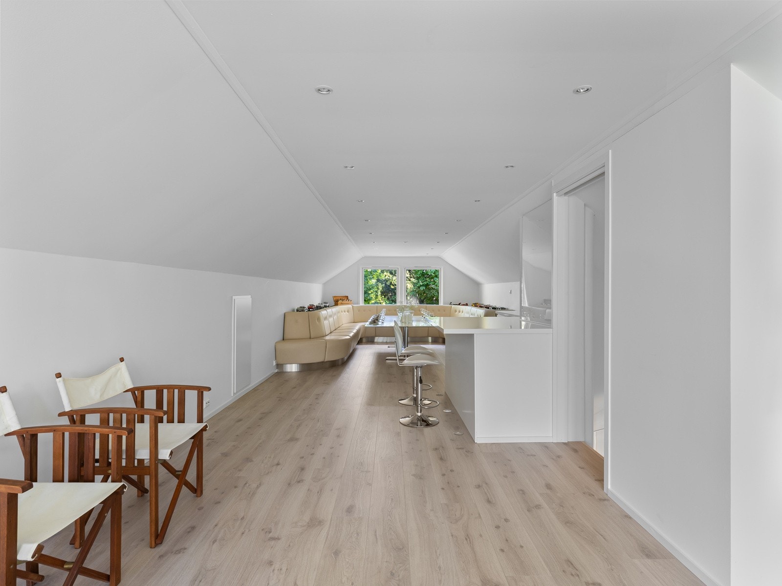 Her er det loungesofa og kjøkkeninnredning med vask og plass til barkrakker. Galleribilde