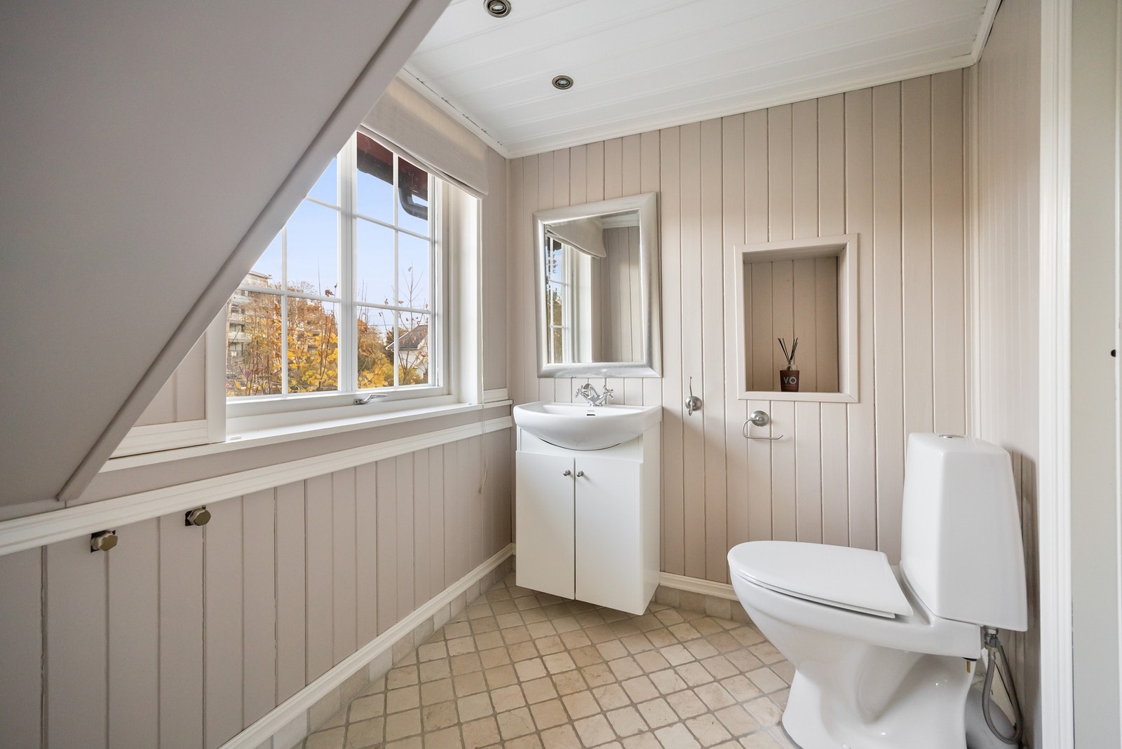 Toalettrommet har malt panel på veggene, flislagt gulv med varmekabler og malt panelt himling Galleribilde