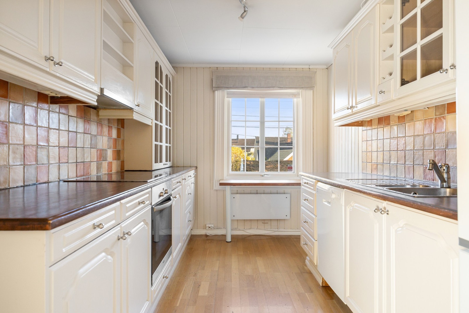 Kjøkkenet har innredning med profilerte fronter og heltre benkeplater. Galleribilde