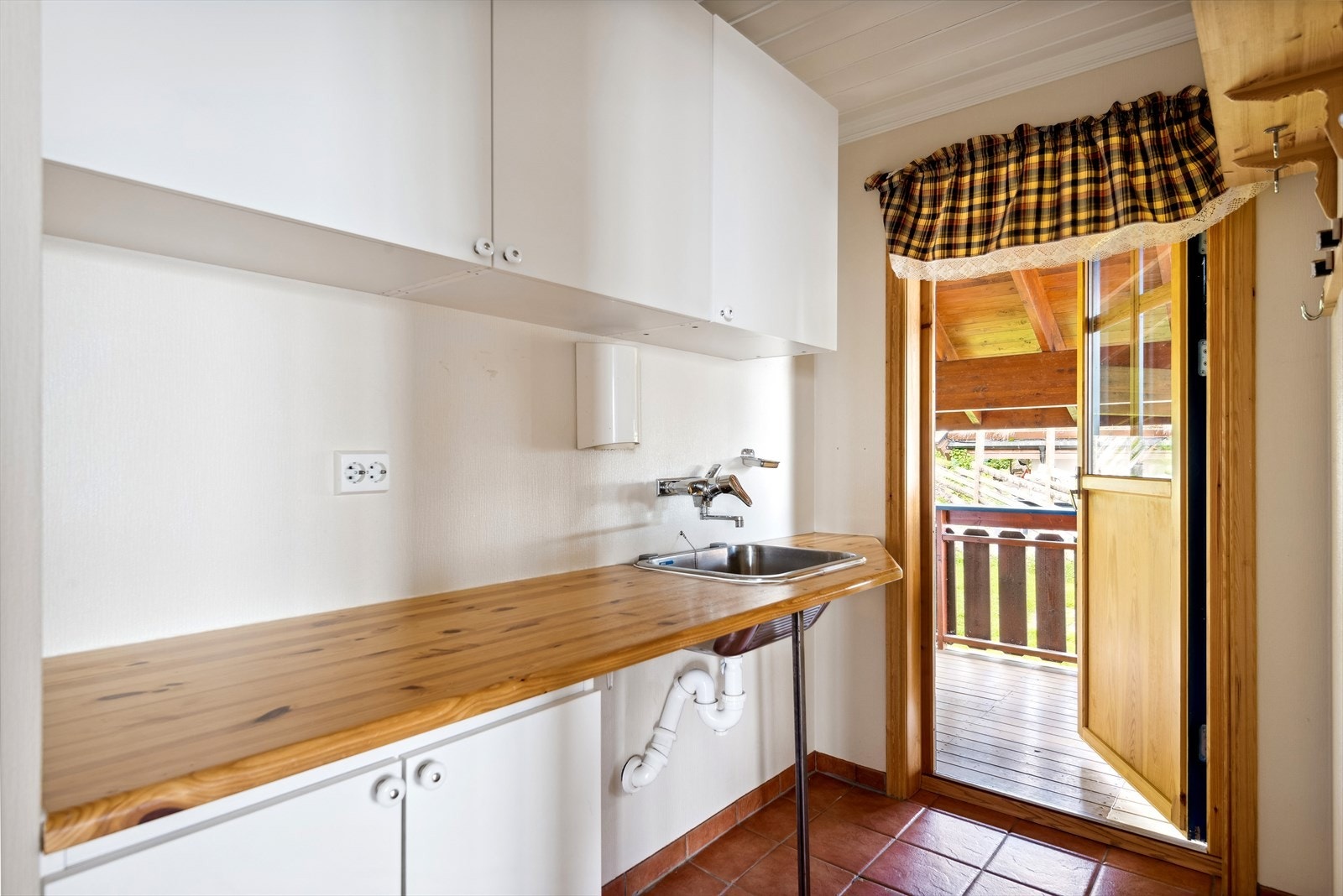 Vaskerommet er fra byggeår og inneholder innredning med slette fronter, vask i rustfritt stål med 1-greps armatur, benkeplate i heltre og opplegg for vaskemaskin. Galleribilde