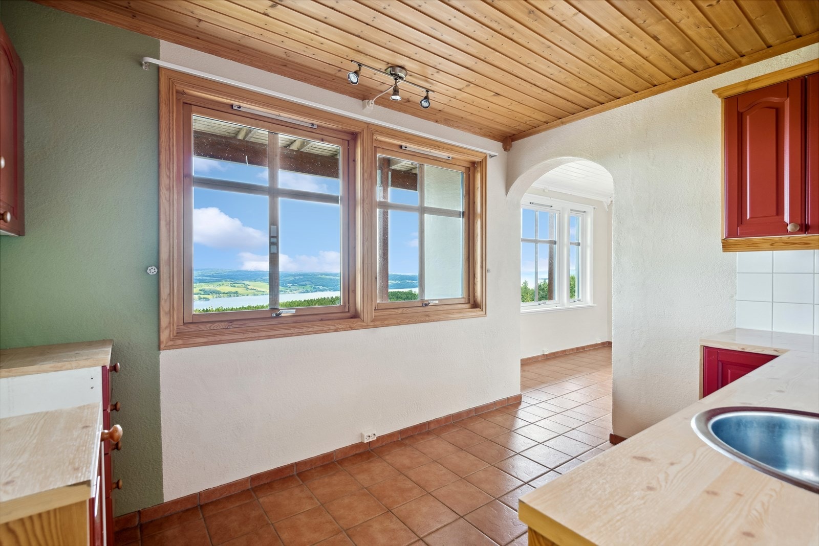 Kjøkkenet i underetasjen inneholder kjøkkeninnredning med laminerte skrog, profilerte fronter og laminert benkeplate med kjøkkenkum. Galleribilde