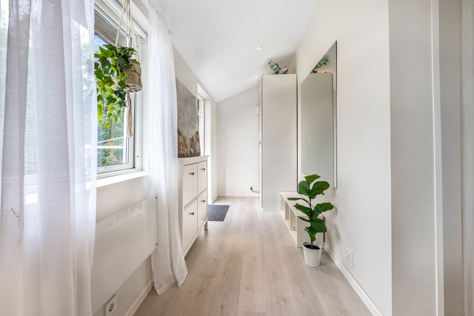 Laminatgulv og lyse vegger og tak, som skaper en lys og trivelig overgang mellom boligens rom. Galleribilde