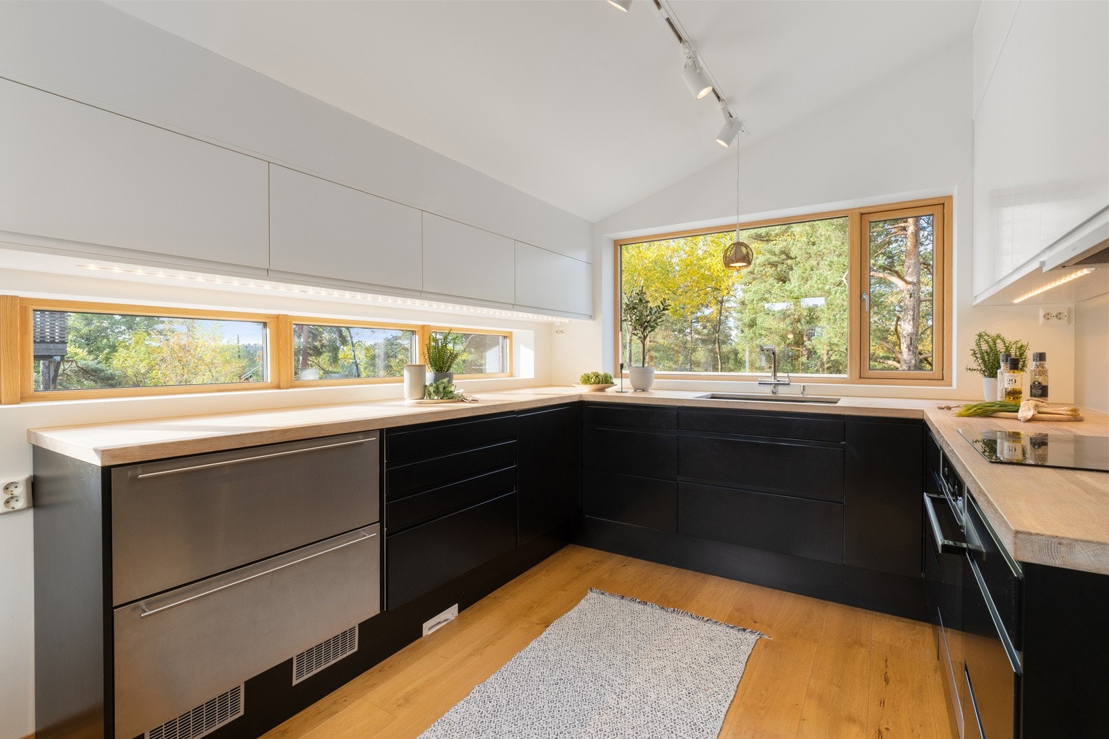 Kjøkken fra Epoq med glatte fronter og heltre benkaplate. Integrerte hvitevarer (oppvaskmaskin, nedfelt intuksjonstopp, stekeovn og kjøleskuffer Galleribilde