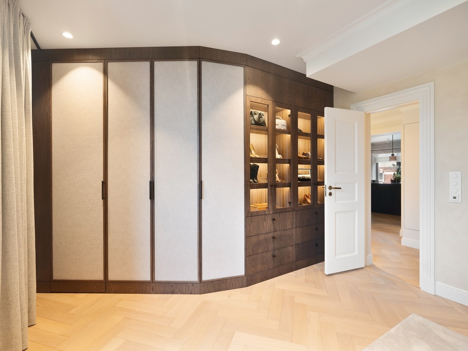 Garderobe med glassdører, lukkede skap, synlige hyller og belysning. Galleribilde