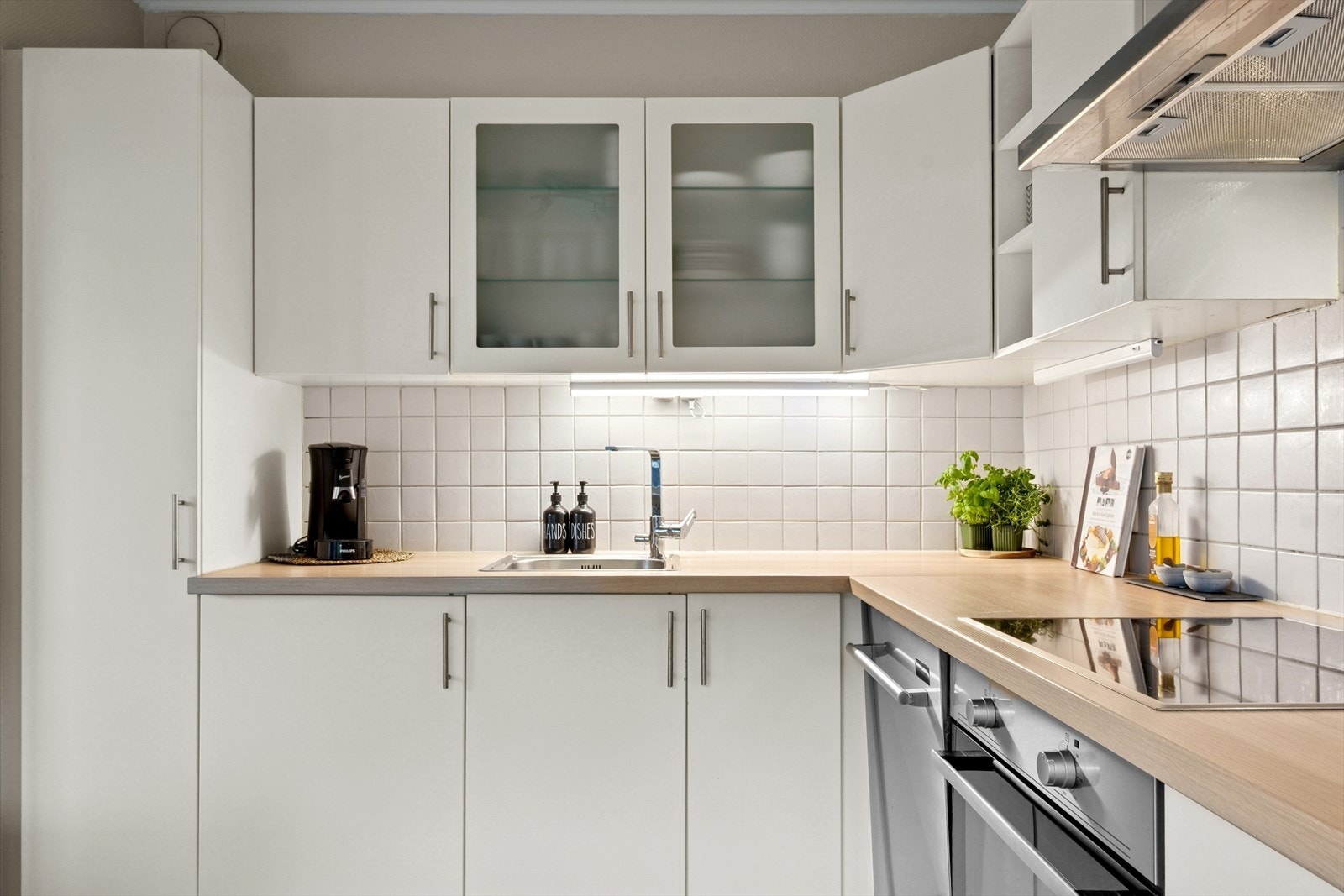 Kjøkkeninnredningen er pen o tidløs med lyse, profilerte fronter og laminert benkeplate med nedfelt kum. Galleribilde