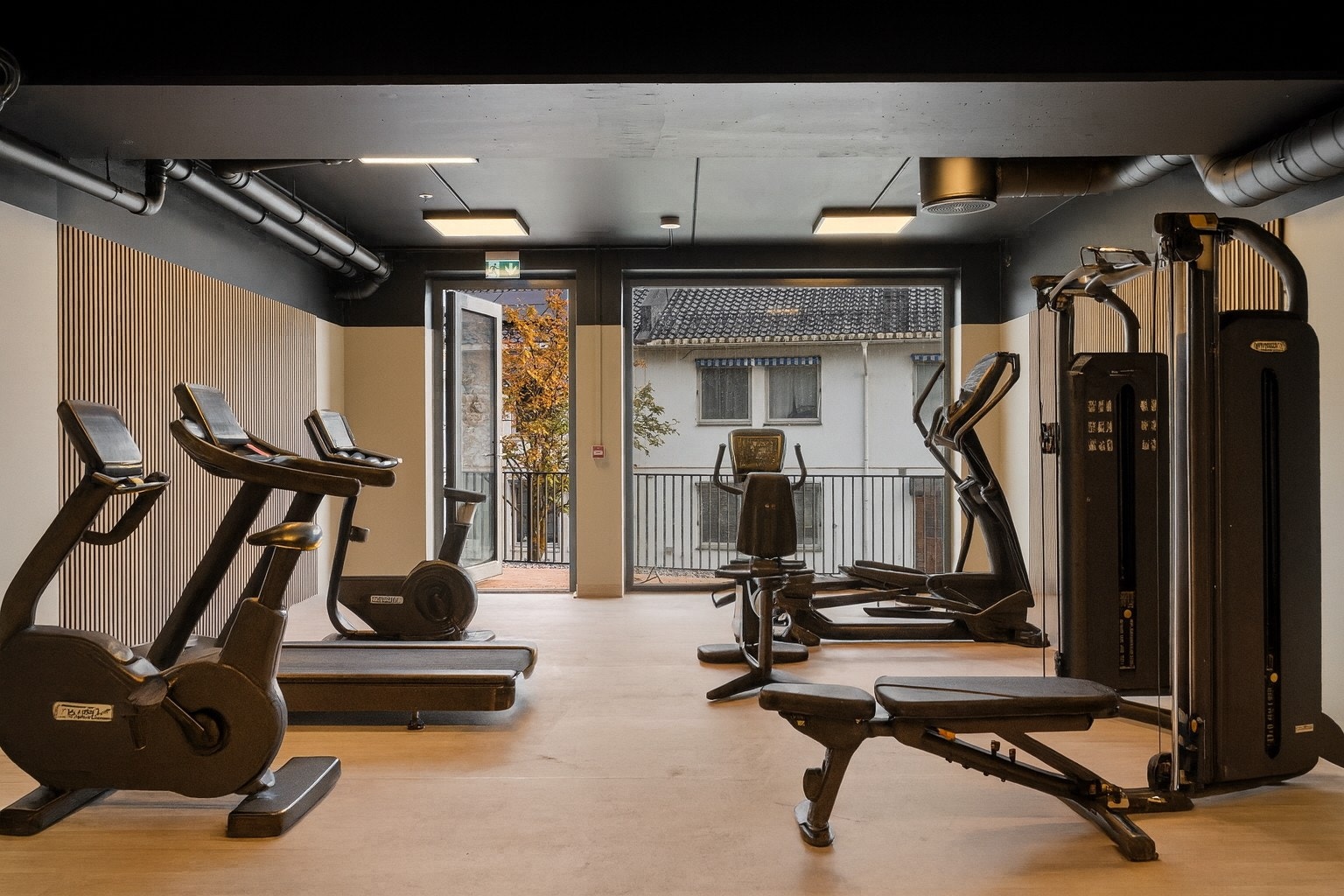 Med tilgang fra både garasjen og fellesområdet er det fullverdig treningsrom samt hobbyrom utstyrt med arbeidsbenker (treningsutstyret er kun en illustrasjon) Galleribilde