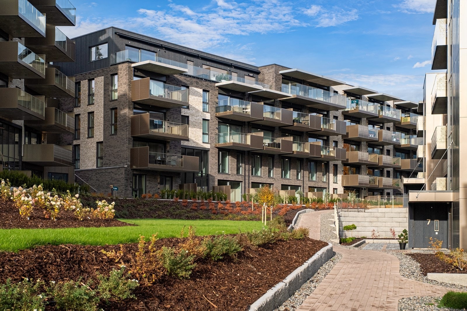 De vakkert opparbeidede fellesområdene vil bestå av grønne plener, beplantning og gangveier som binder bebyggelsen sammen på en naturlig måte Galleribilde