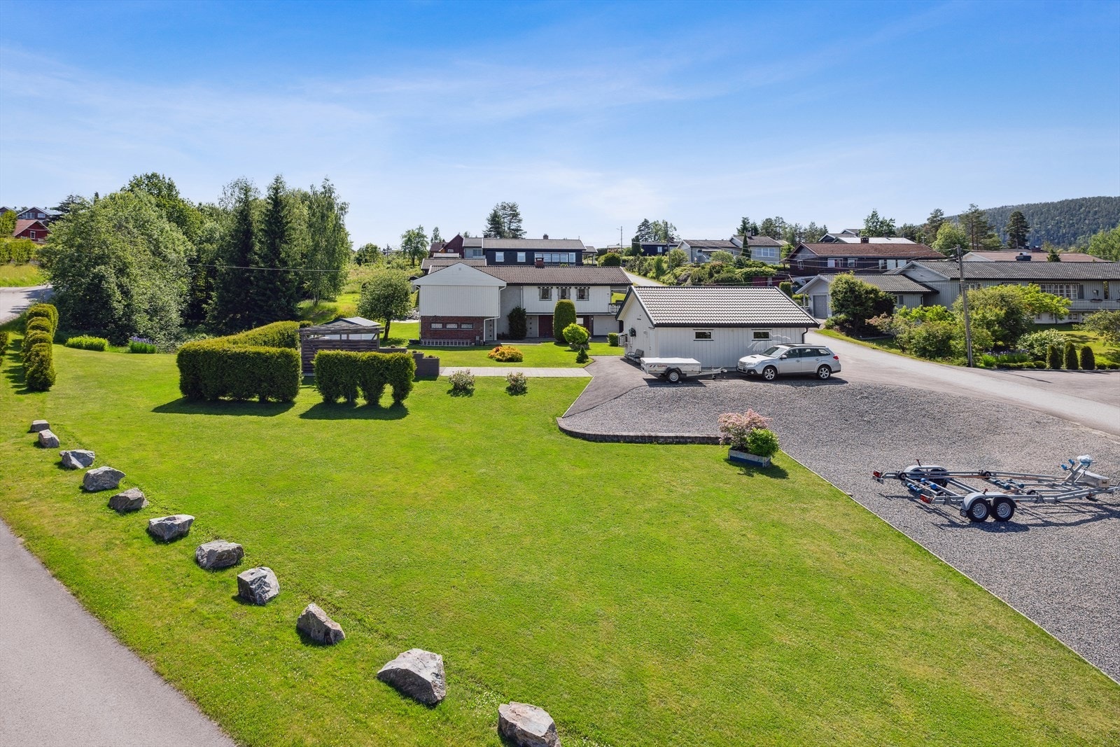 Romslig gårdsplass med plass til flere biler. Tomten har en enebolig med utleiedel, og en frittliggende, isolert garasje med vann og avløp Galleribilde
