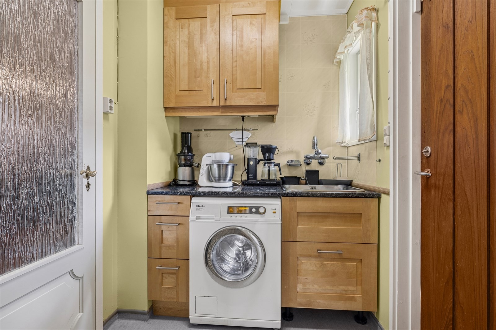 Vaskerommet har vinylbelegg på gulvet med oppkant langs veggene, samt malte veggflater. Det er montert opplegg for vaskemaskin, og vaskerommet har egen utgang til hagen Galleribilde