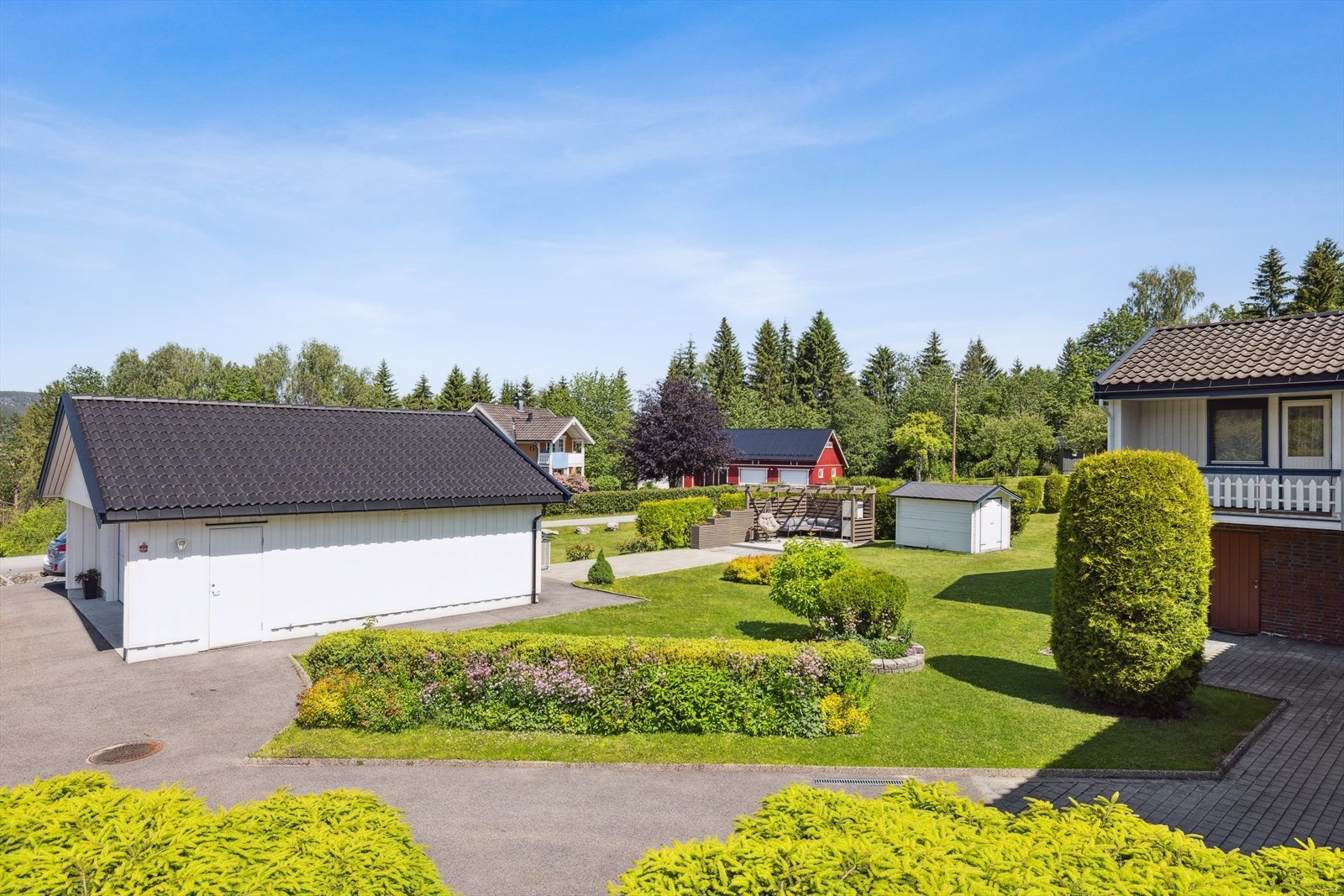 Eiendommen ligger på en stor og velstelt tomt over 2 mål med solrike uteplasser og flere fine soner for lek og avslapning. Galleribilde