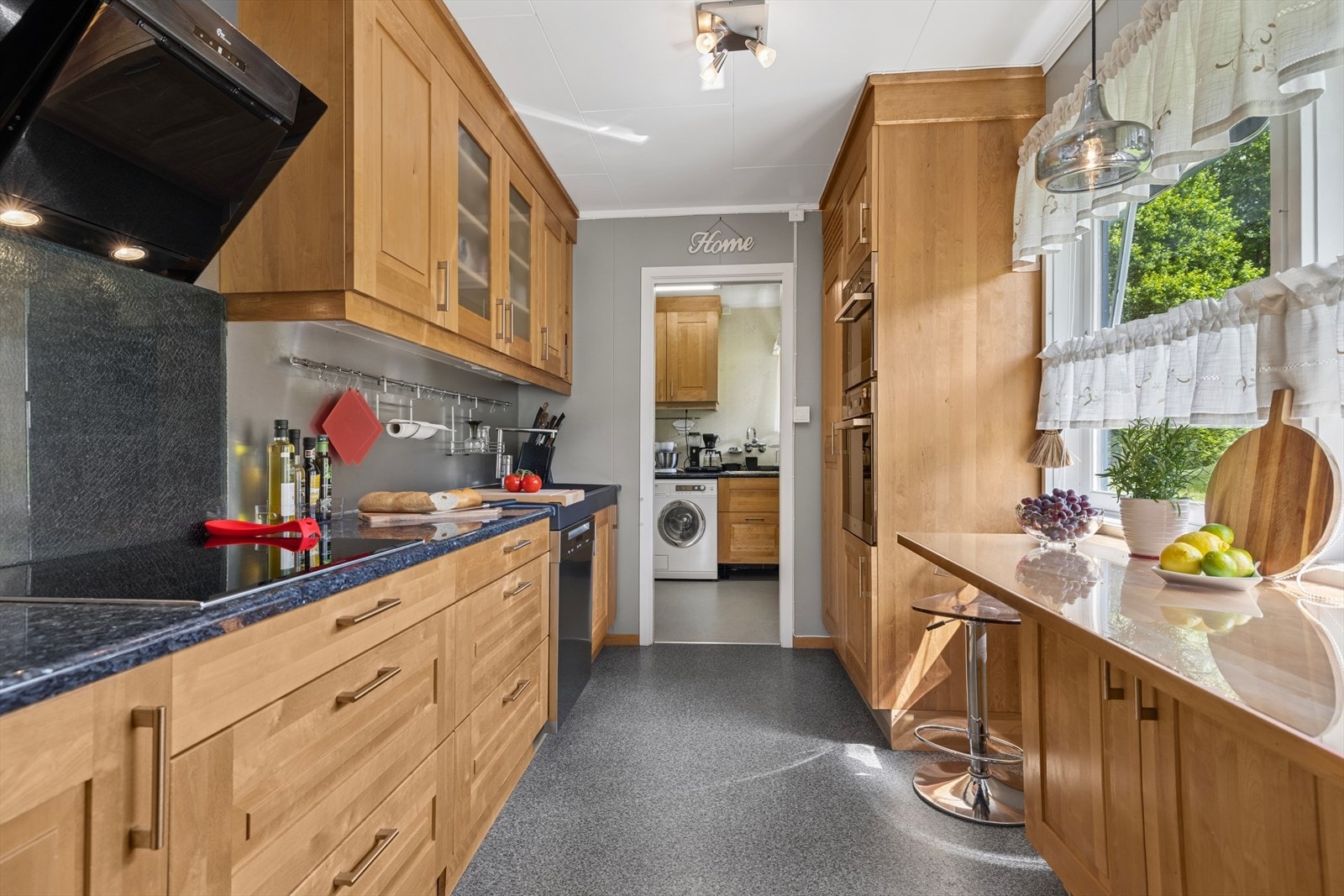 Godt med benke- og skapplass gjør kjøkkenet til et funksjonelt og innbydende rom hvor matlaging blir gøy for liten og stor. Kjøkkenet er utstyrt med kvalitetshvitevarer, med platetopp fra Bosch, stekeovn, dampovn og oppvaskmaskin fra Miele. Galleribilde